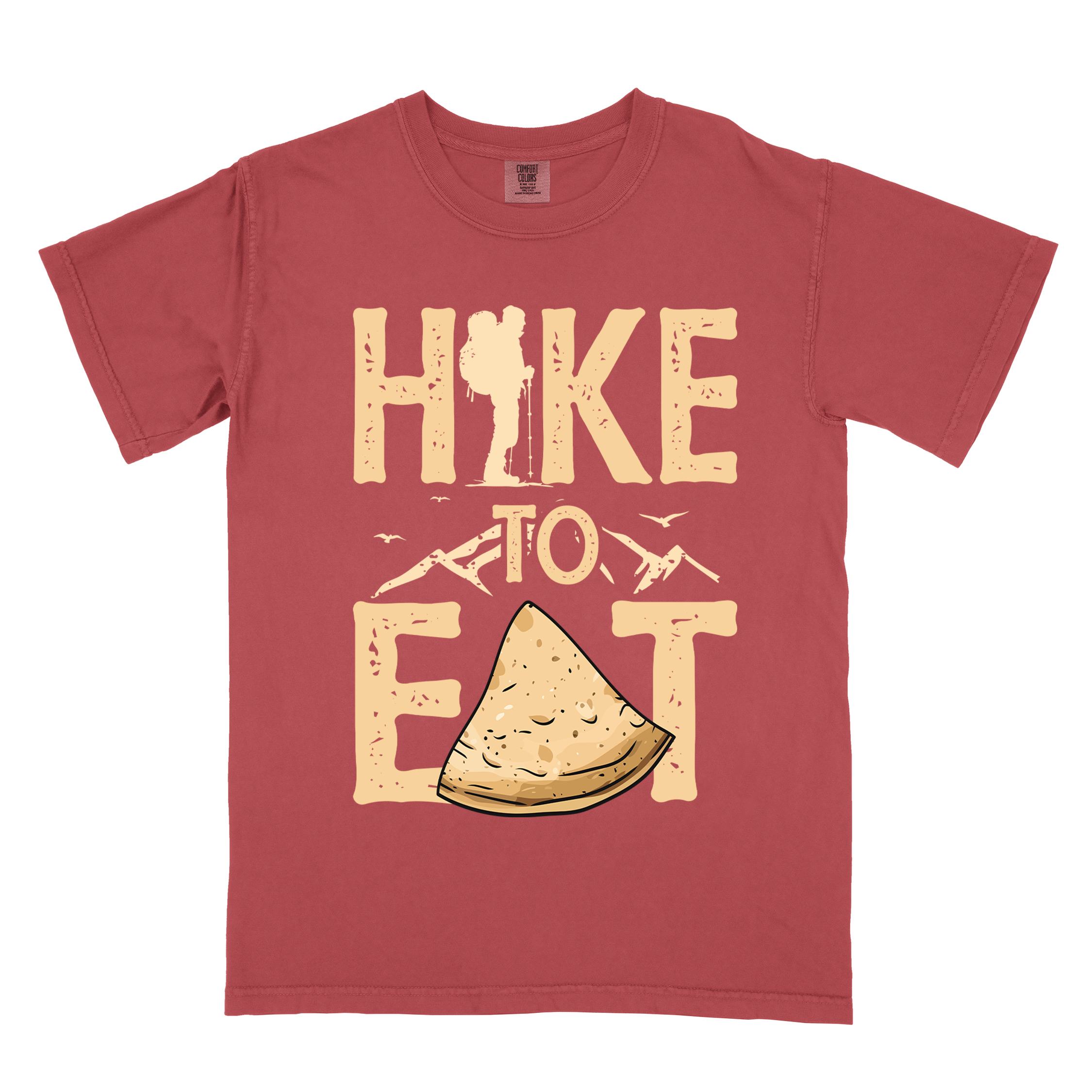 Crimson "Hike to Eat" colored statement tee with bold typography, mountain, illustrated tortilla, perfect for tortilla lovers.