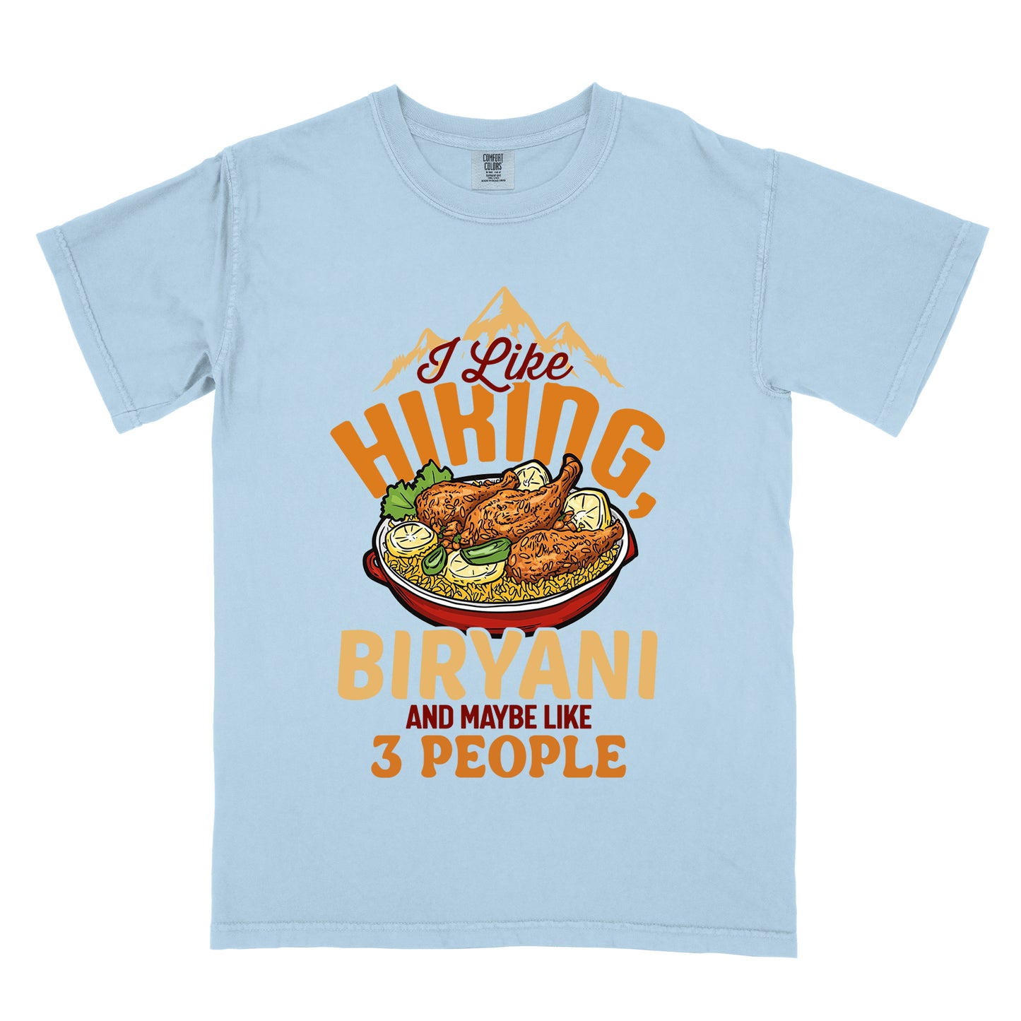 Chambray (Light Blue) t-shirt with text reading "I Like HIKING, BIRYANI AND MAYBE LIKE 3 PEOPLE". Gold mountain silhouettes appear above "I Like" (in dark brown script). "HIKING" is in large orange letters, below which sits a detailed illustration of a red bowl filled with biryani rice and chicken. "BIRYANI" appears in gold letters, while "AND MAYBE LIKE" is in small dark brown text and "3 PEOPLE" in orange.