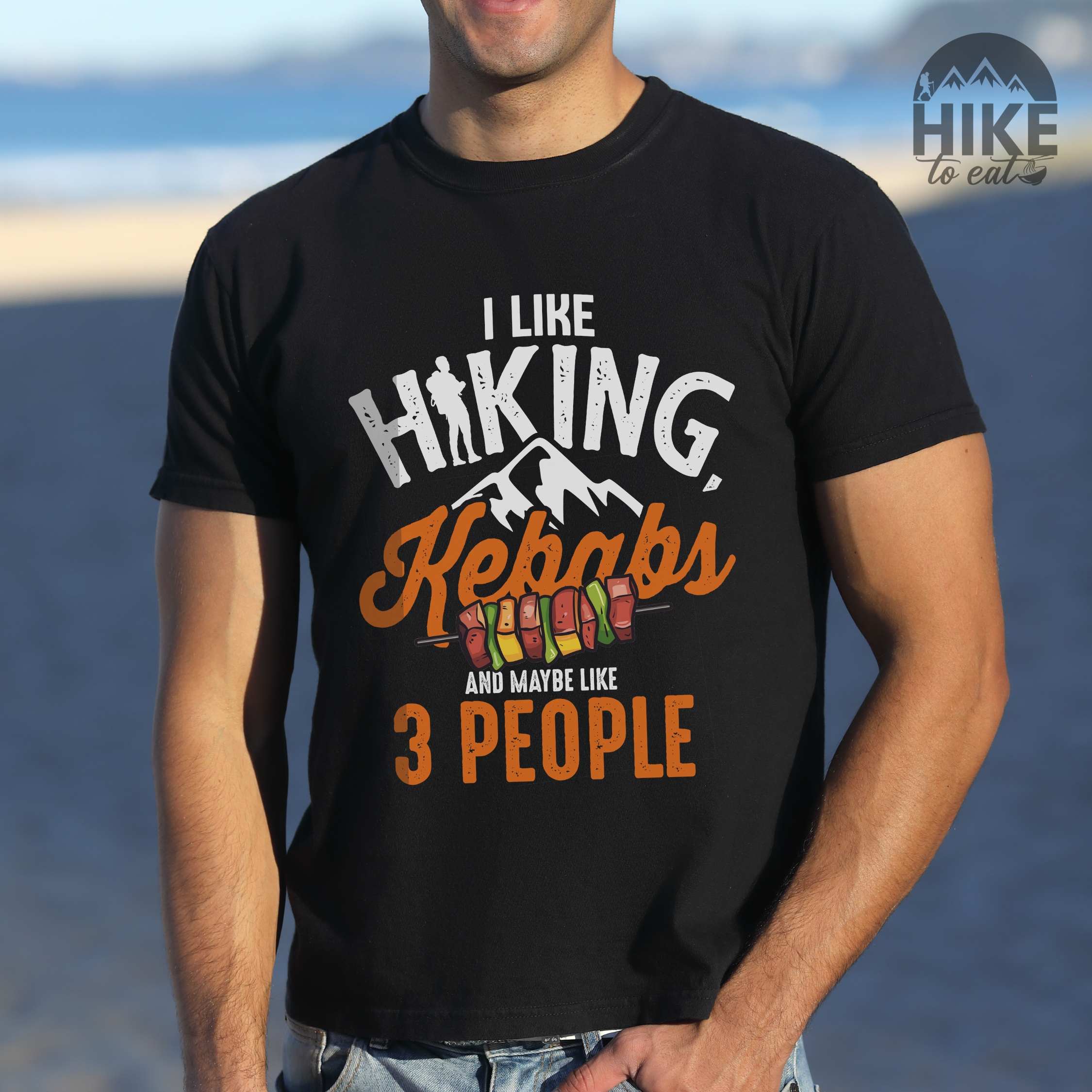 Man wearing black “I Like Hiking, Kebabs and Maybe Like 3 People” colored vintage tee with bold text, mountain, Illustration of grilled kebab. Perfect tee for foodie craving for grilled kebabs,