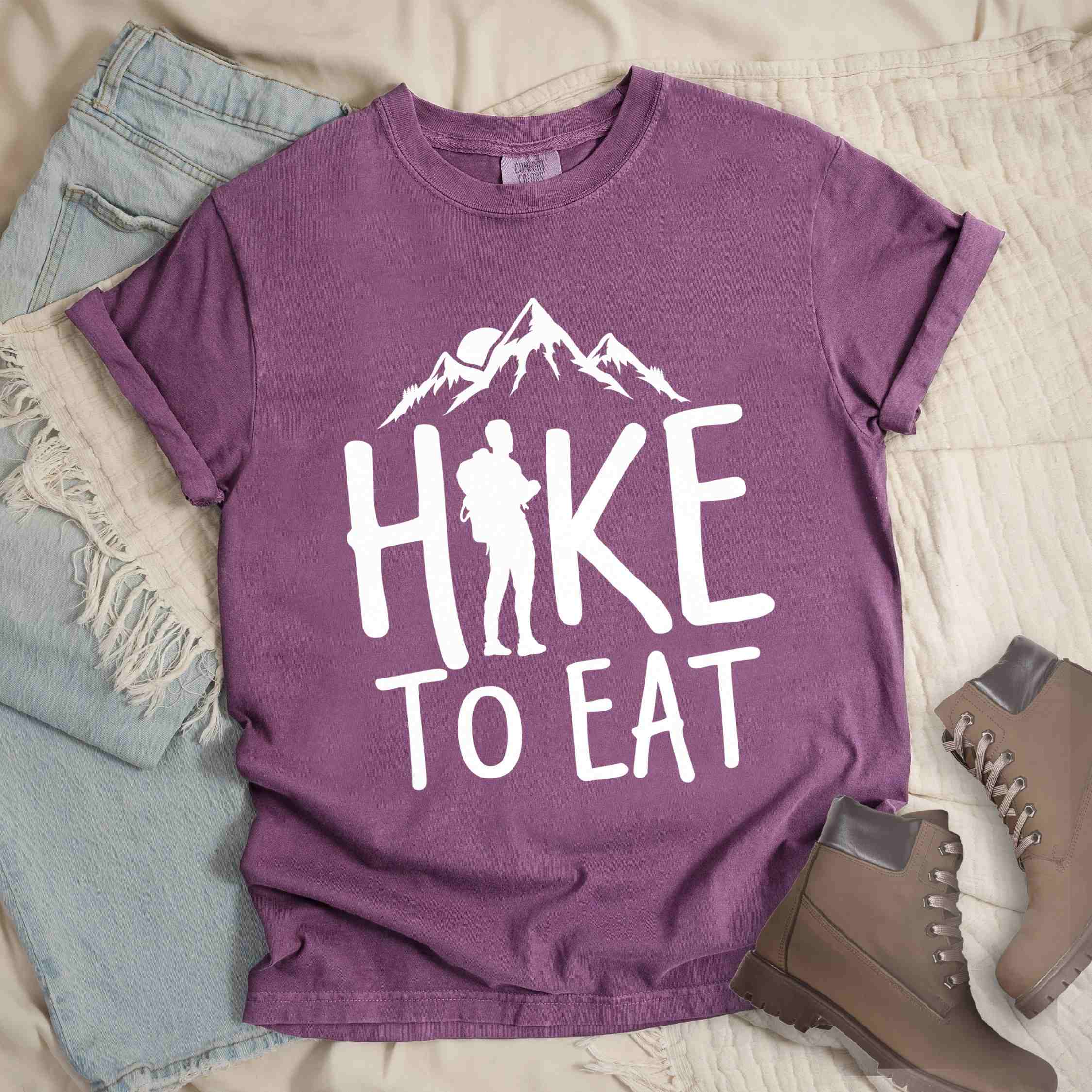 Berry "Hike to Eat" colored statement tee with bold typography, mountains, birds, sunrise, perfect for food motivated individuals.