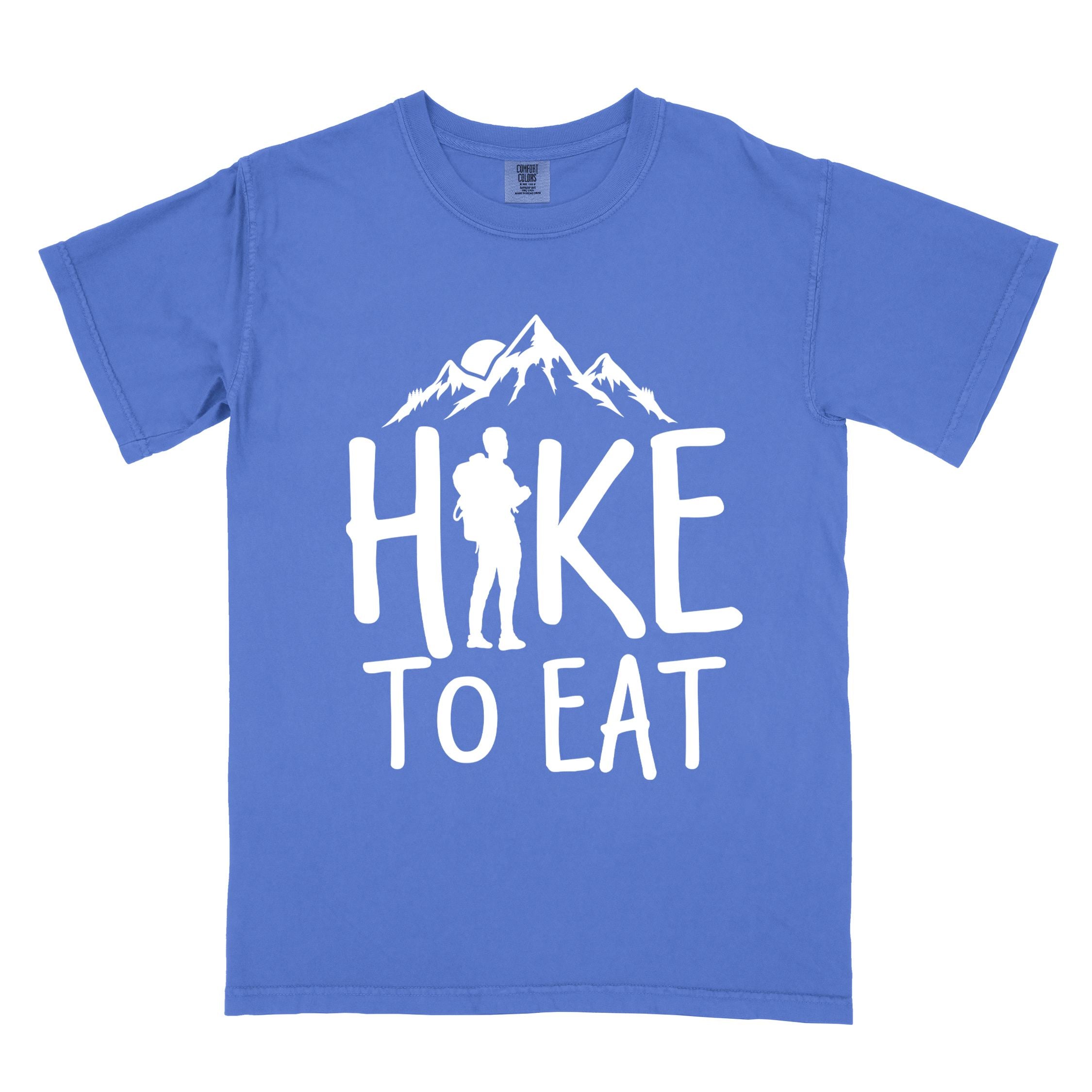 Flo blue "Hike to Eat" colored statement tee with bold typography, mountains, birds, sunrise, perfect for food motivated individuals.