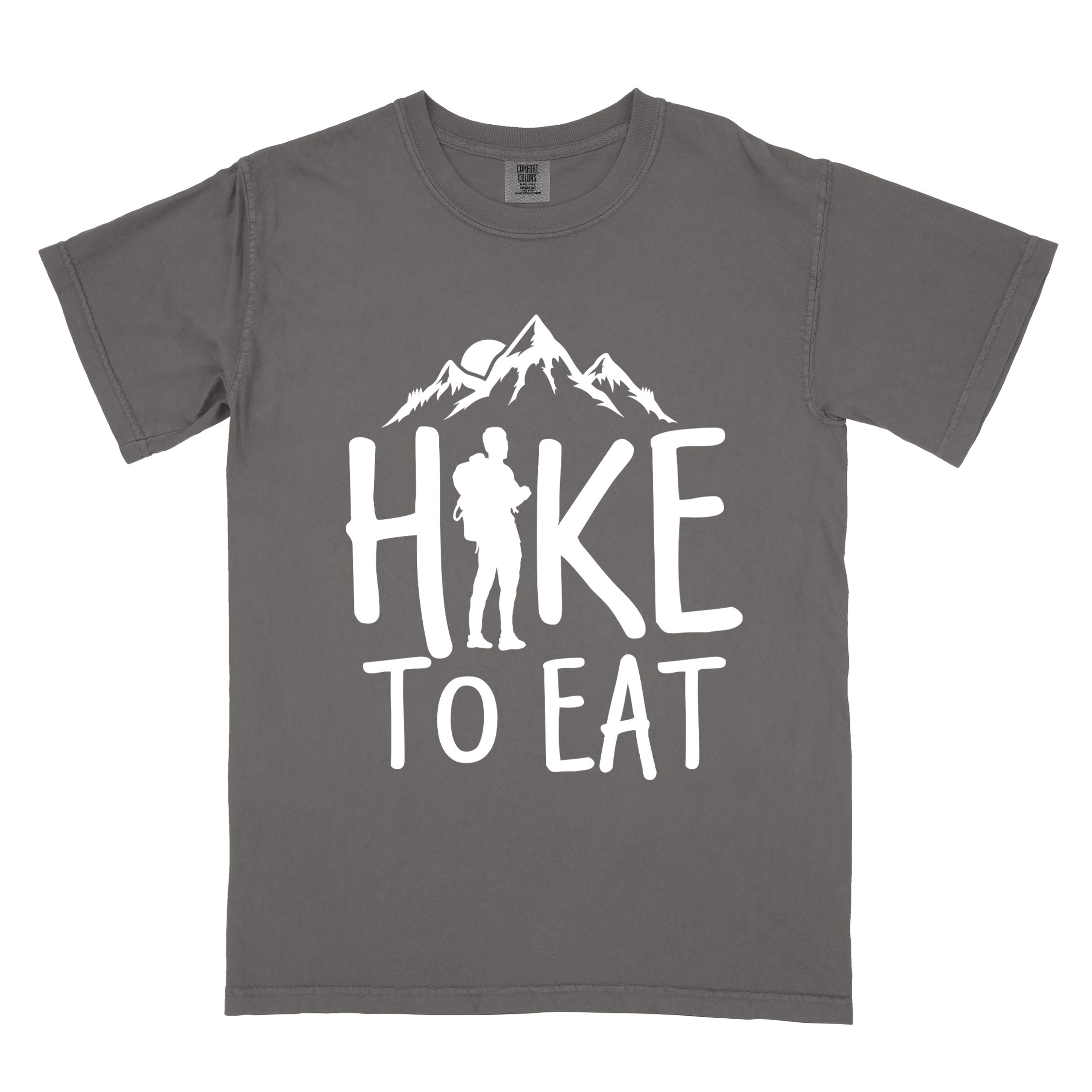 Pepper "Hike to Eat" colored statement tee with bold typography, mountains, birds, sunrise, perfect for food motivated individuals.