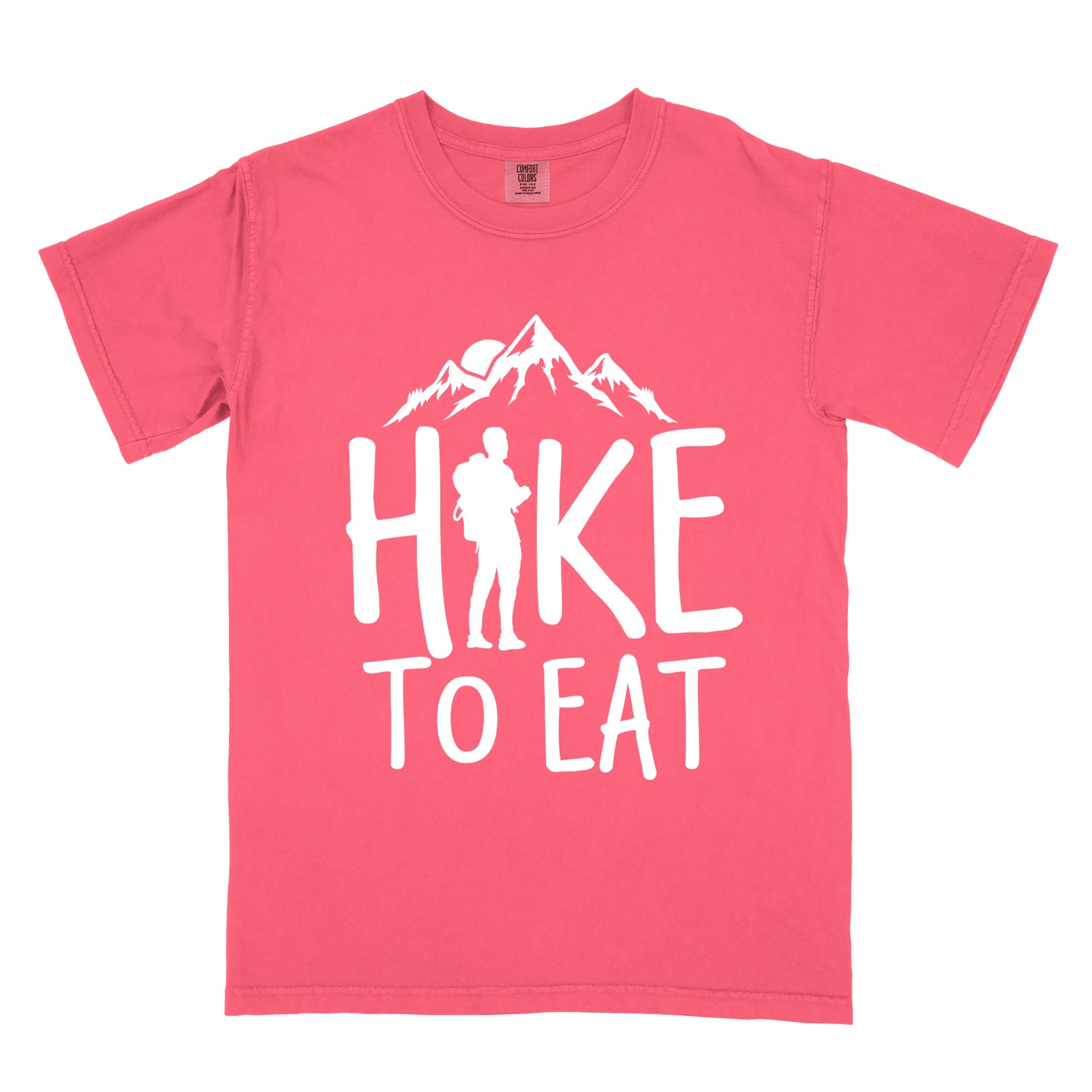 watermelon "Hike to Eat" colored statement tee with bold typography, mountains, birds, sunrise, perfect for food motivated individuals.