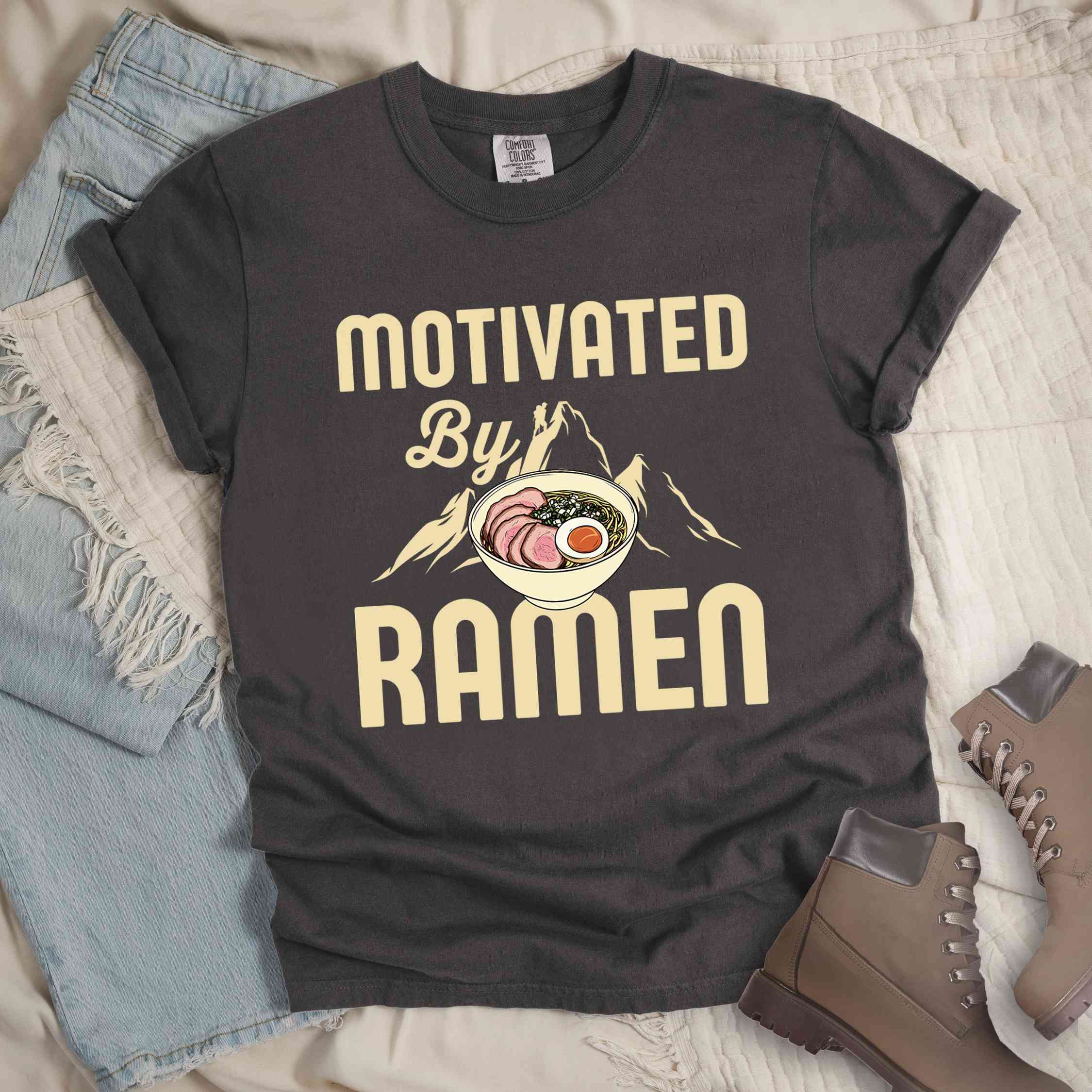 Pepper “Motivated by Ramen” colored vintage tee with bold text, mountain, Illustration of hot ramen. Perfect tee for foodie craving for a bowl of ramen,