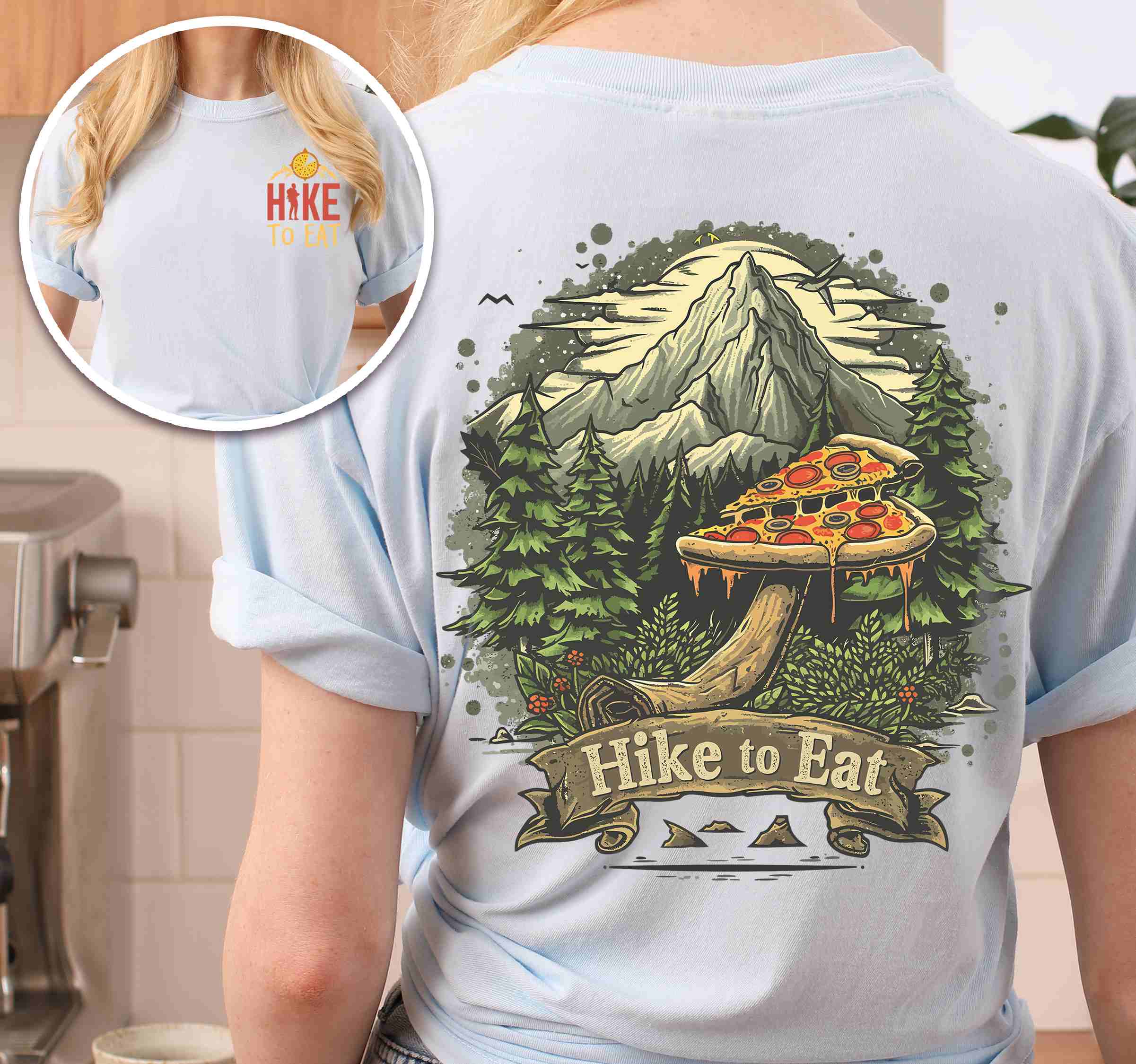 Woman wearing chambray colored vintage tee with front and back design "Hike to Eat" text in cream lettering, mountains, birds, illustrated pizza slice mushroom top, and backpacker for pizza lovers.