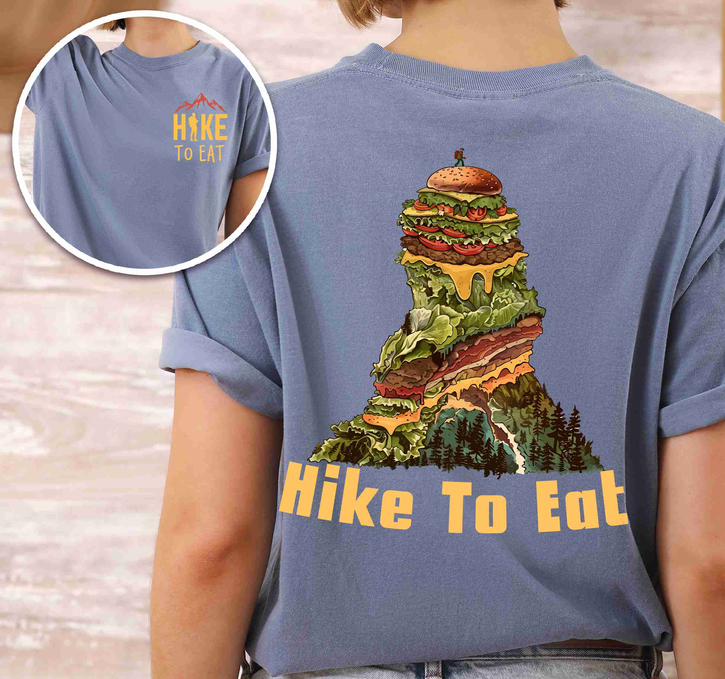 woman wearing blue jean "Hike to Eat" text in bold lettering front and back design, mountains, birds, illustrated stack of cheeseburger, and backpacker for burger lovers.