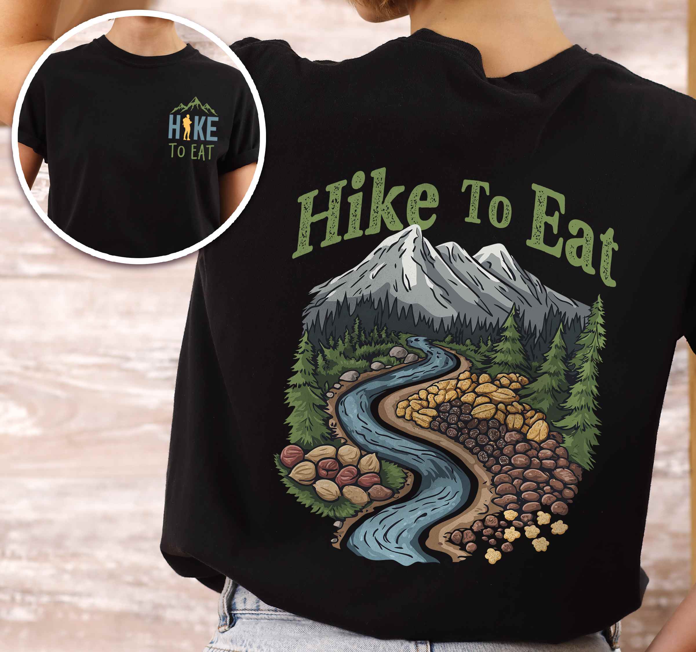 Woman wearing black "Hike to Eat" text in bold lettering front and back design, mountains, birds, illustrated nuts and fruit trail mix, and backpacker for trail mix lover.