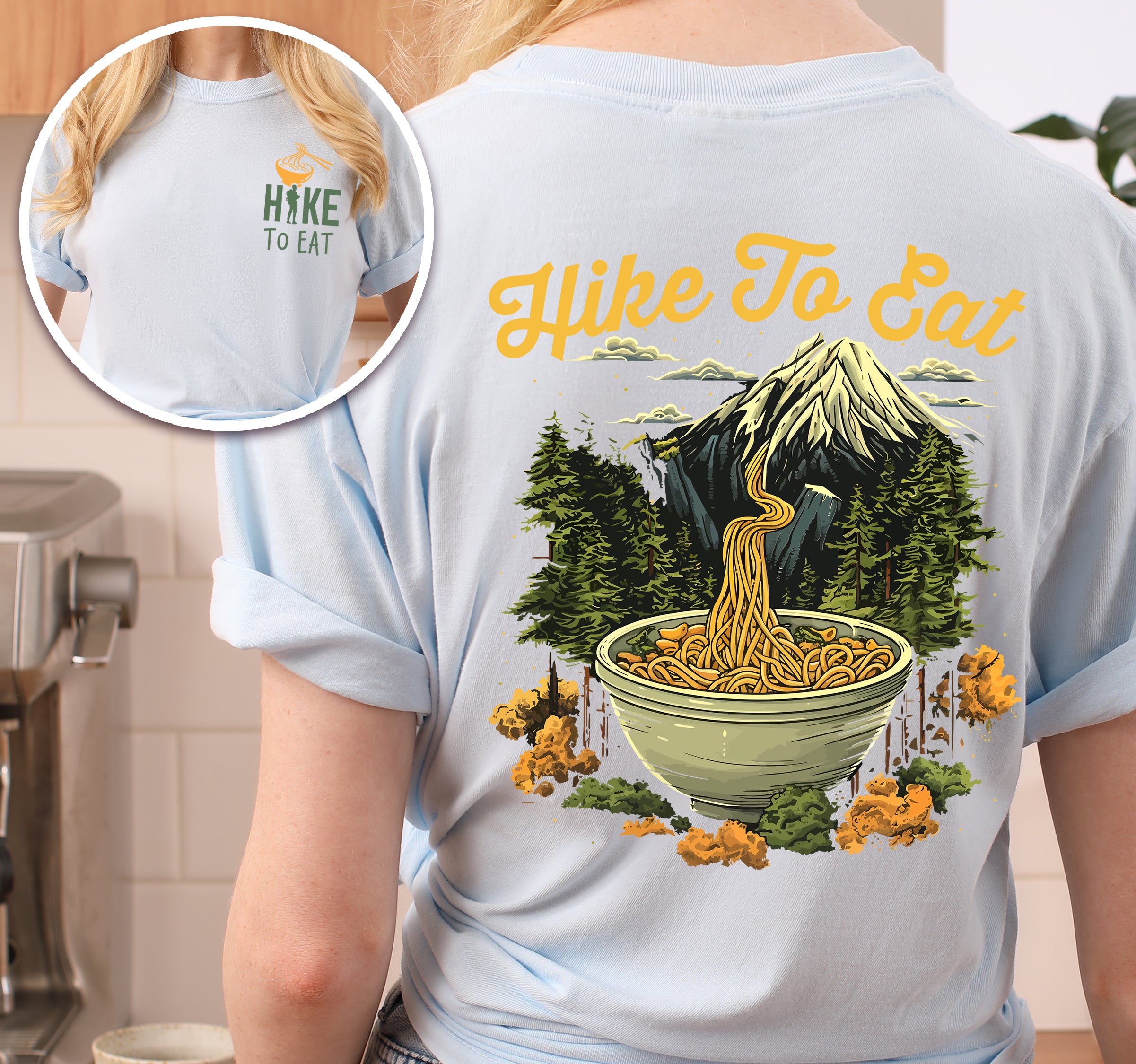 Chambray (Light Blue) colored Hike to Eat t-shirt front and back view showing small colorful chest logo and large back design featuring ramen noodle bowl with mountain landscape background, and pine trees.