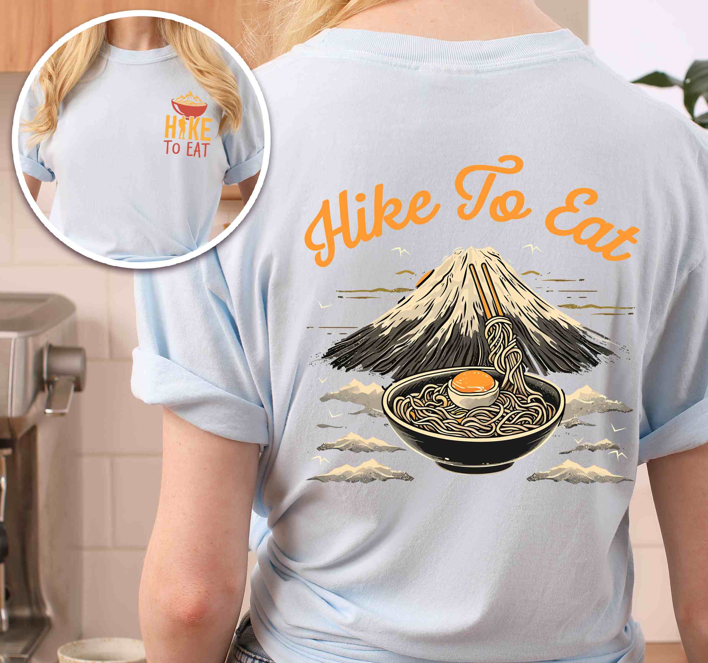 Woman wearing chambray "Hike to Eat" text in bold lettering front and back design, mountains, birds, illustrated bowl of ramen noodles, and backpacker for ramen lovers.