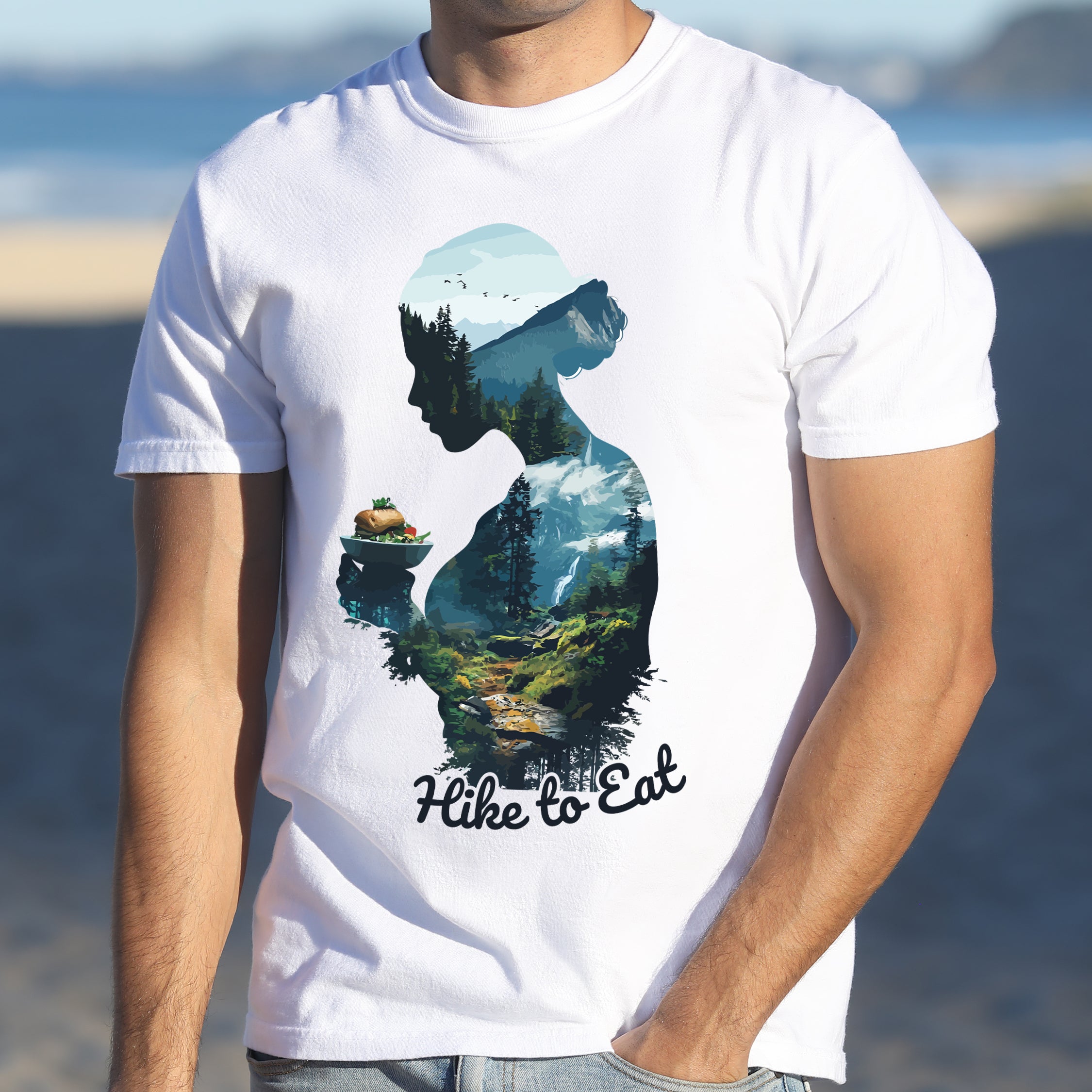 A man wearing Wilderness Within Hike to Eat t-shirt featuring double exposure design of hiker silhouette holding plate with sandwich / burger merged with mountain forest landscape on Comfort Colors shirt in white color 