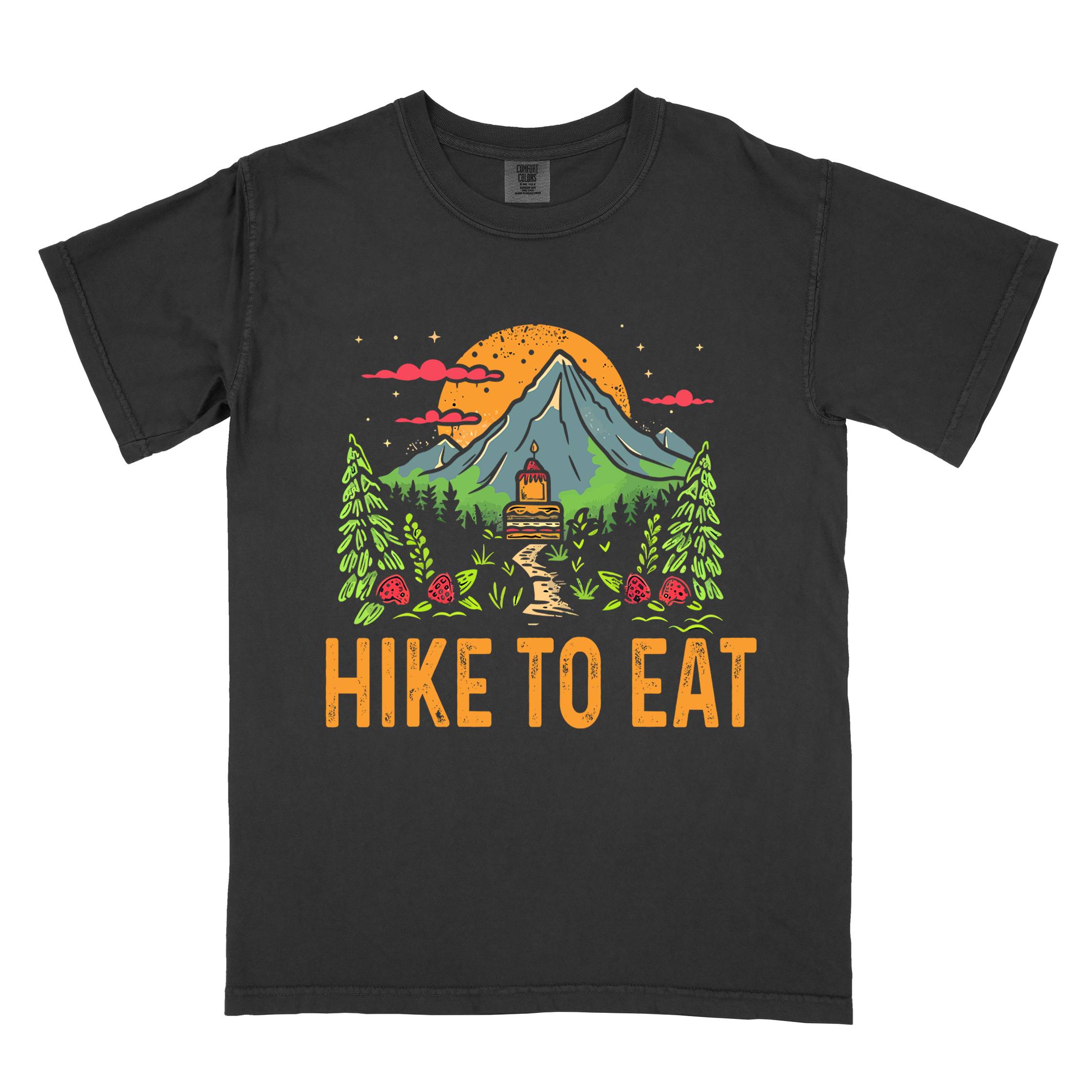 Black "Hike to Eat" colored vintage statement tee with text in cream lettering, mountains, birds, silhouette, illustrated tiered cake, and perfect for cake lovers.