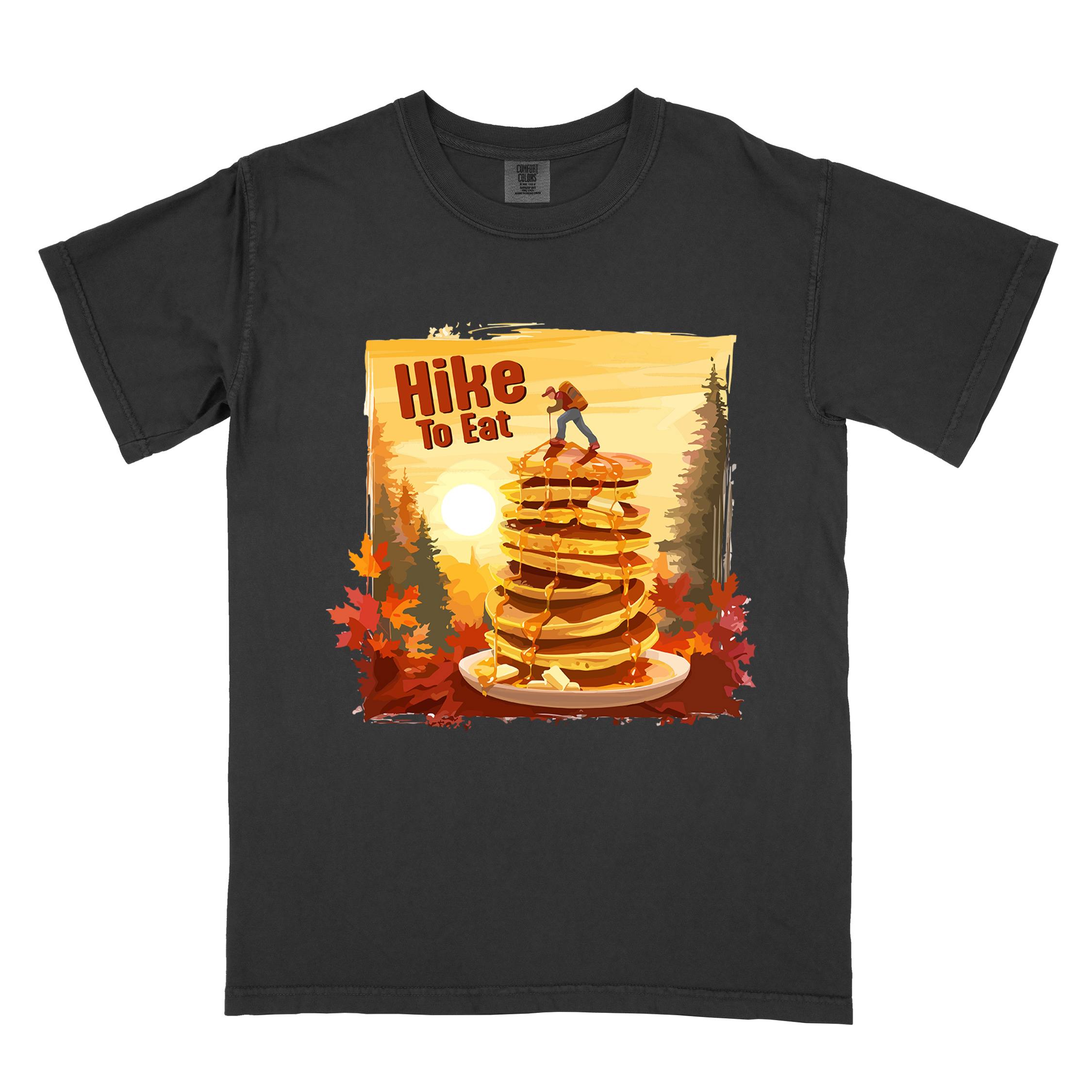 Black "Hike to Eat" colored vintage statement tee with text in bold lettering, mountains, birds, silhouette, illustrated stack of pancake, and perfect for breakfast lovers.