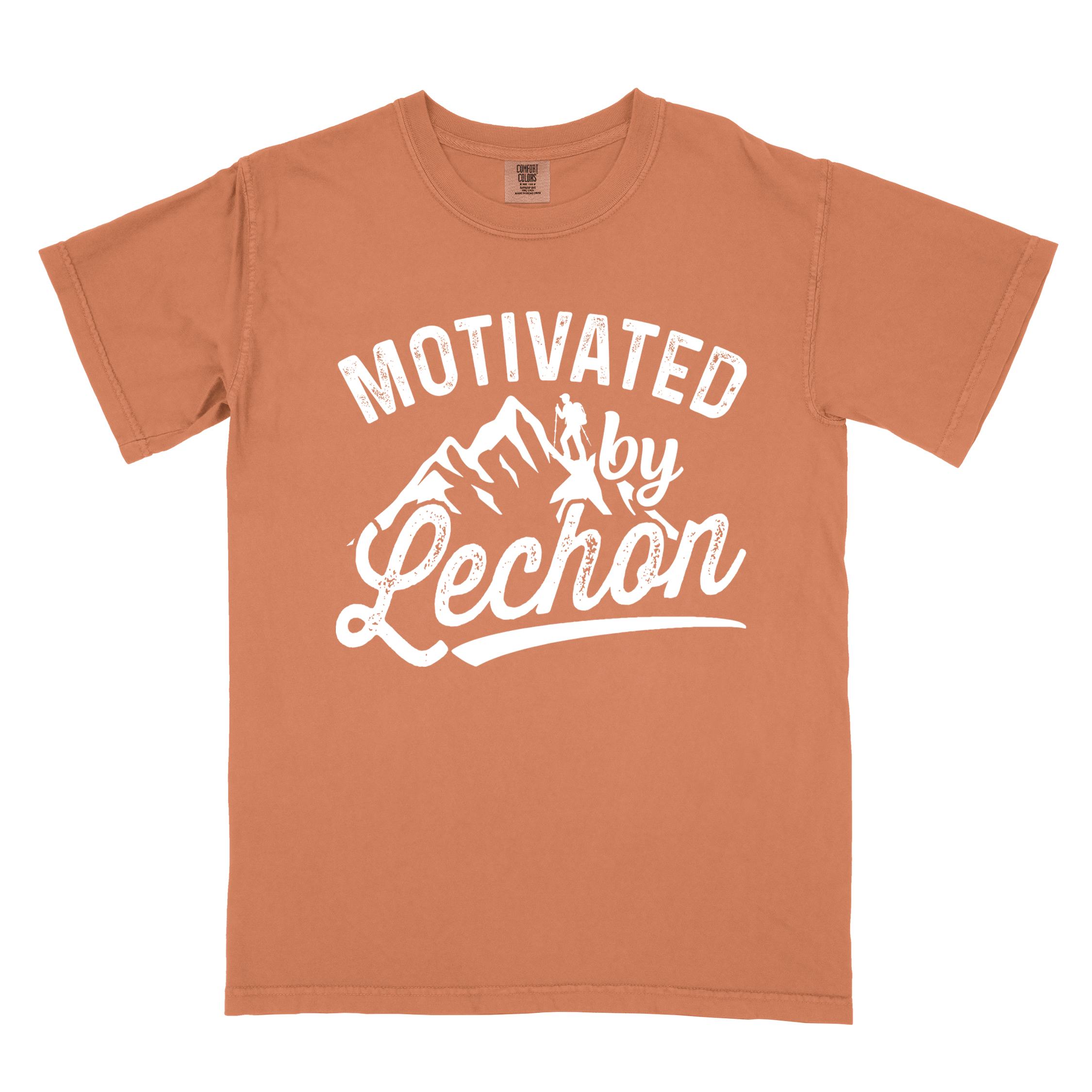 Yam colored graphic t-shirt with 'Motivated by Lechon' text in white lettering featuring mountain silhouettes and hiker illustration