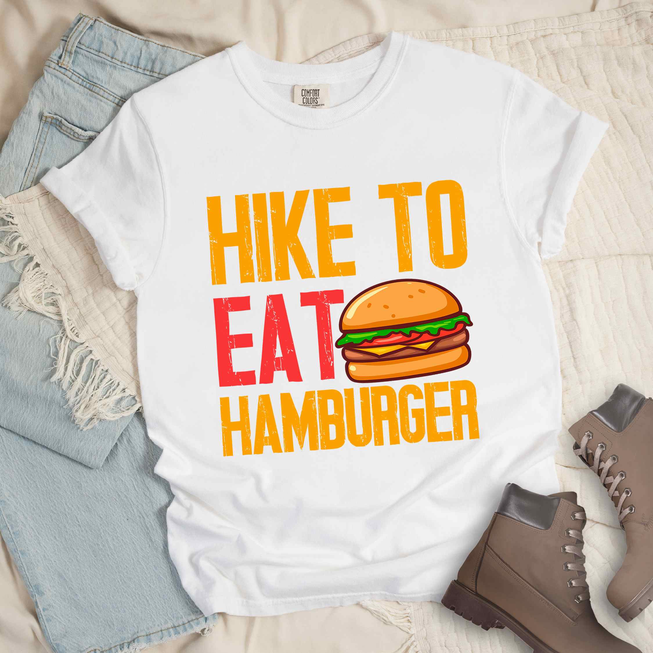 White "Hike to eat Hamburger" colored vintage tee with bold typography, juicy cheese hamburger illustration, perfect for the hamburger enthusiasts.