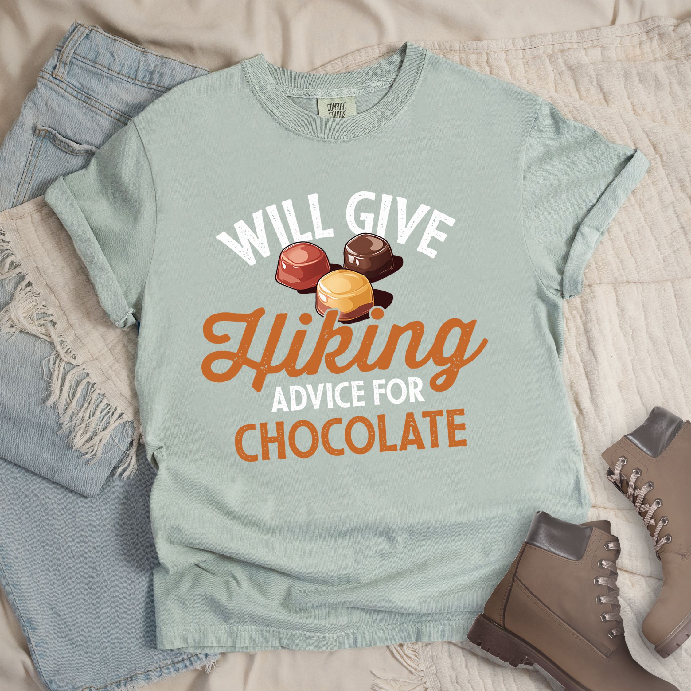Light grey shirt with the text “Will Give Hiking Advice for Chocolate” featuring stylized lettering and an illustration of assorted chocolate candies.