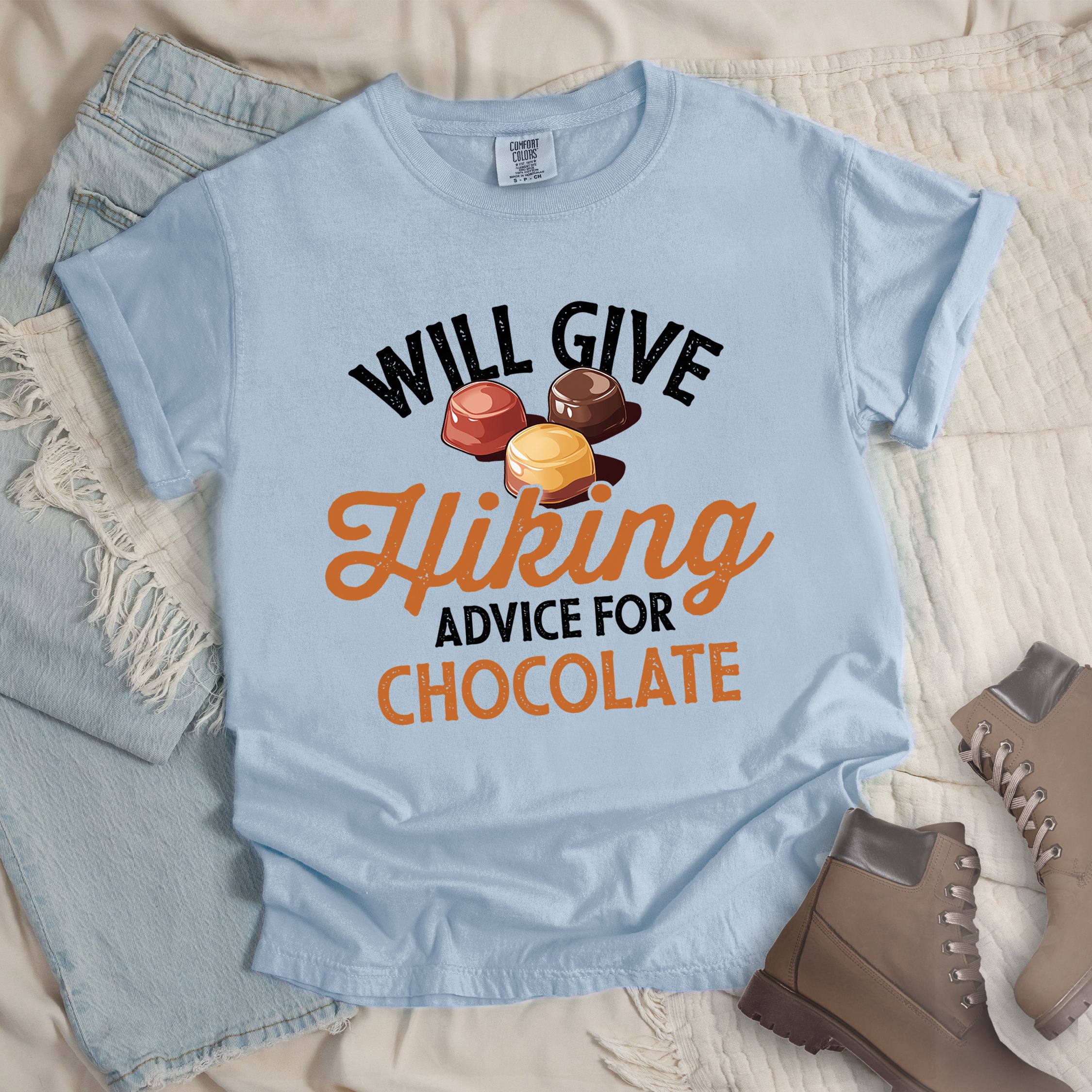 Light blue shirt with the text “Will Give Hiking Advice for Chocolate” featuring stylized lettering and an illustration of assorted chocolate candies.