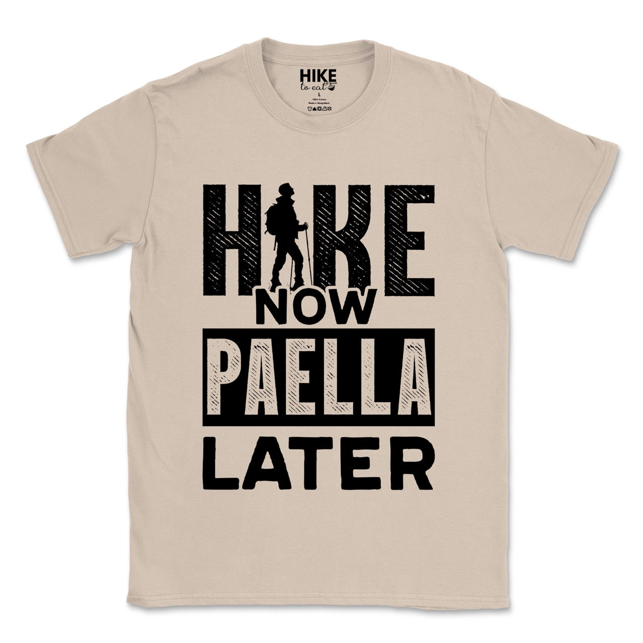 sand (beige) Hike Now Paella Later statement tee with bold distressed typography and hiker silhouette for Spanish food-loving outdoor enthusiasts and hikers