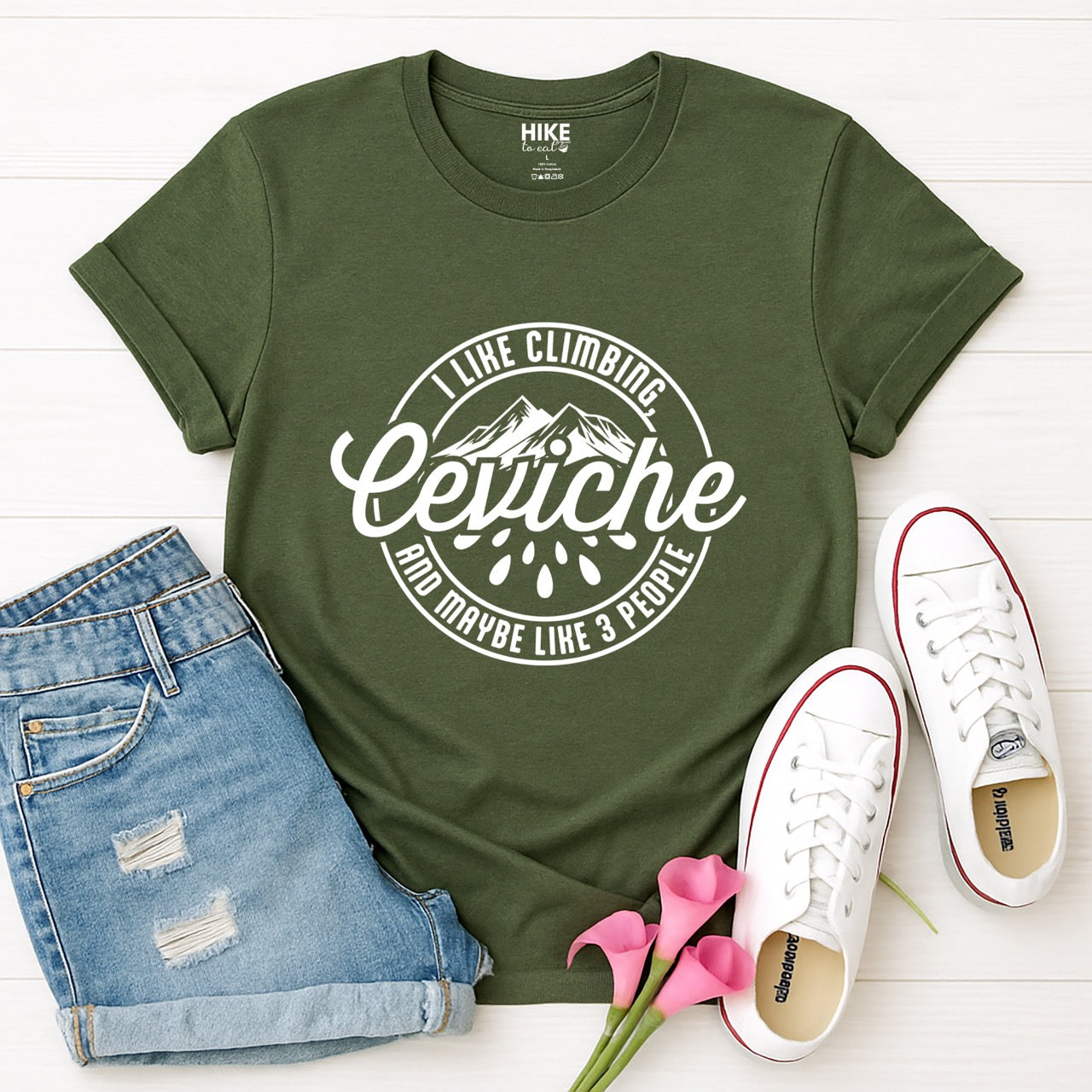 Military Green I like Climbing, Ceviche and maybe 3 People funny introvert statement tee with circular badge design, mountain peaks, and citrus drops for seafood-loving climbers, hikers and foodies laid flat with shorts and shoes
