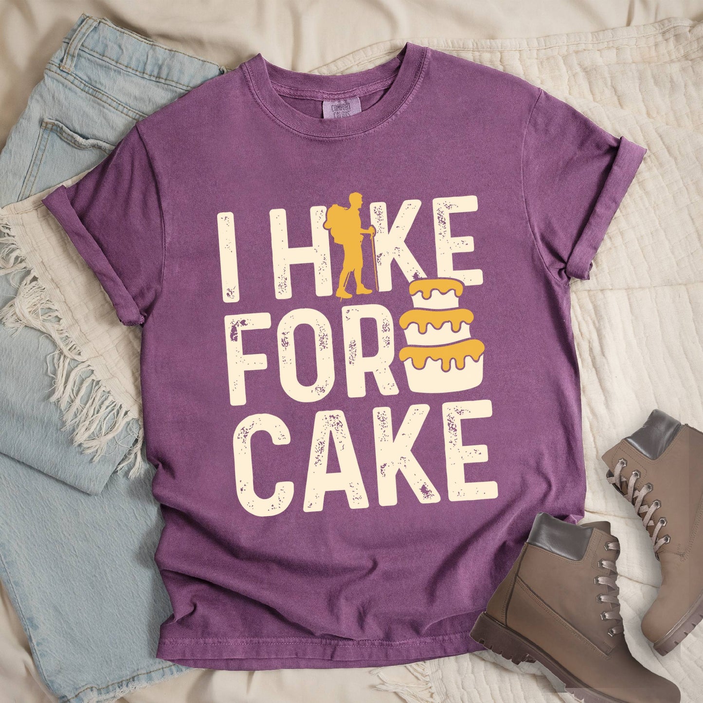 Dark pink shirt with the bold text “I Hike for Cake” and an illustration of a layered cake with frosting.