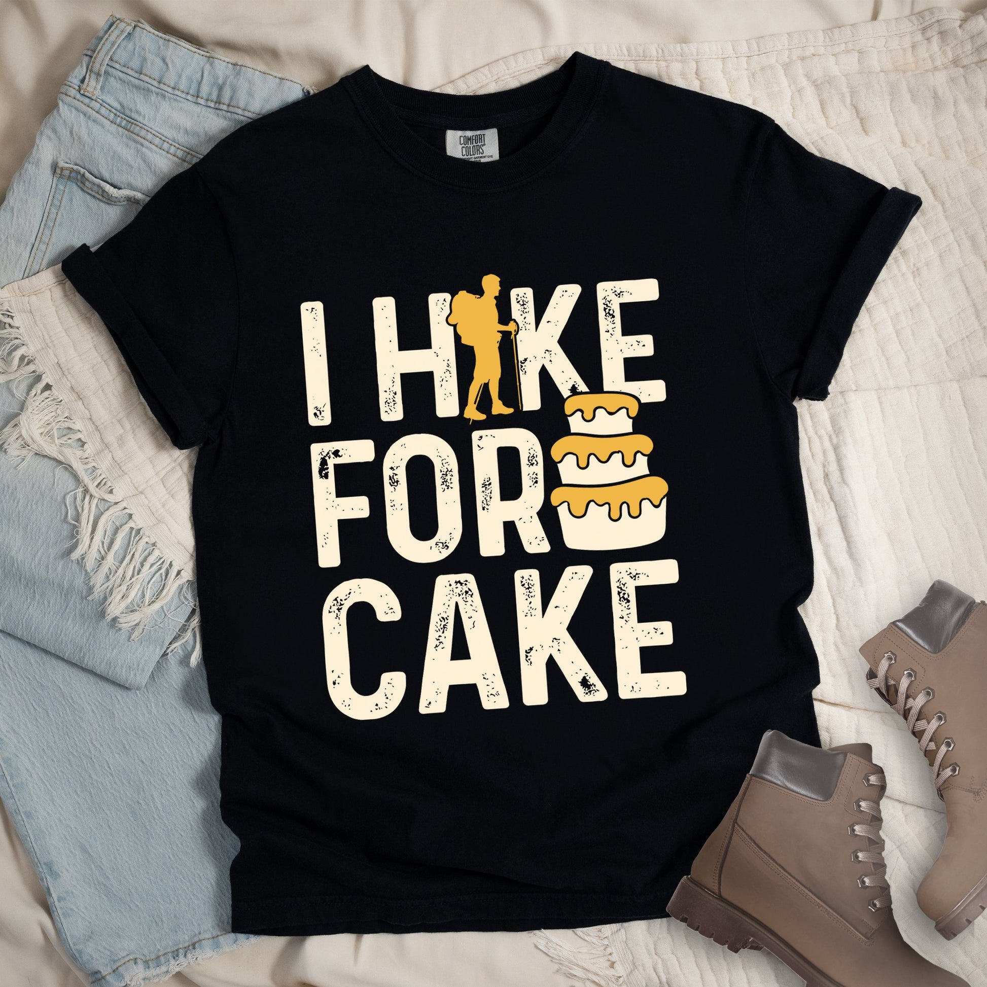 Black shirt with the bold text “I Hike for Cake” and an illustration of a layered cake with frosting.