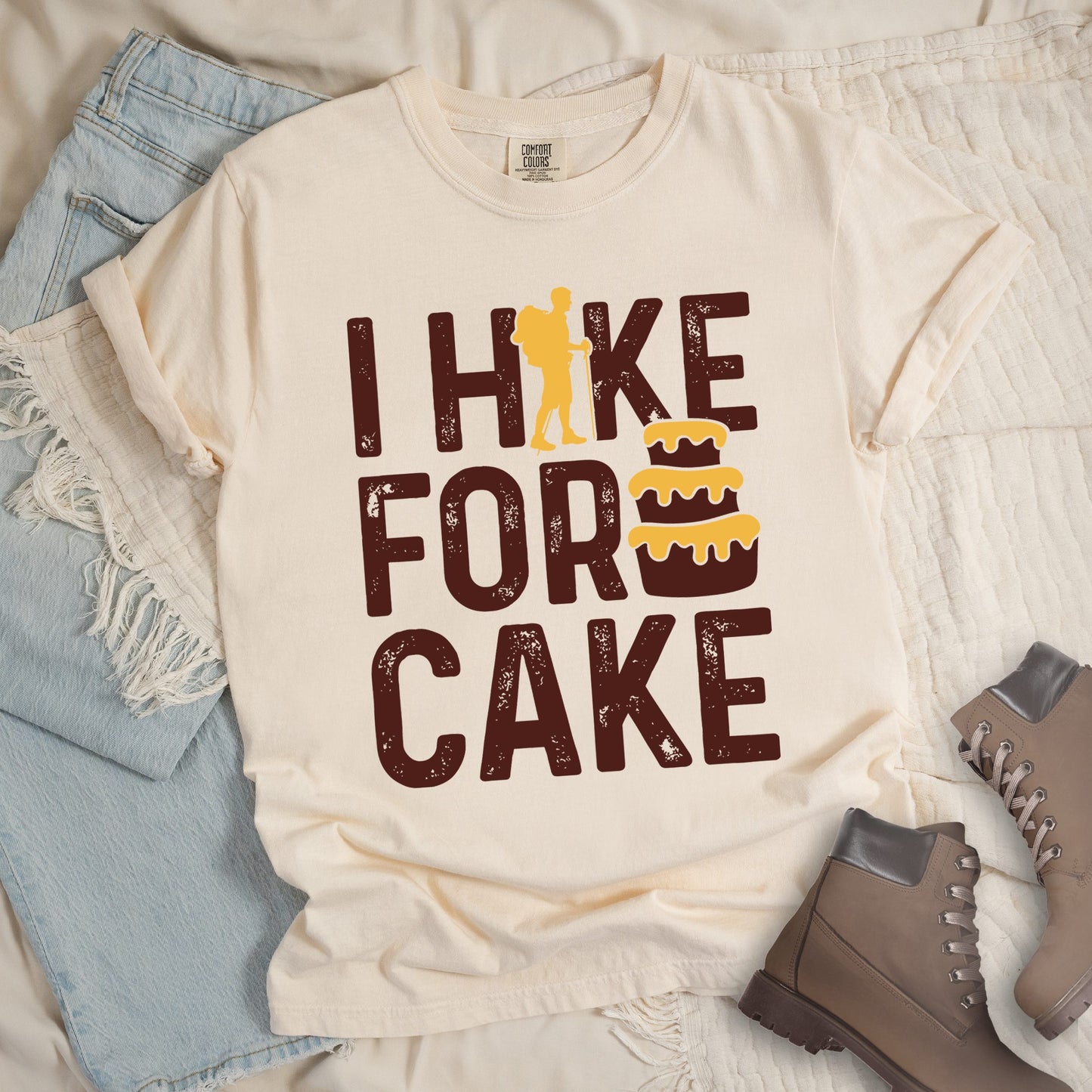 Ivory shirt with the bold text “I Hike for Cake” and an illustration of a layered cake with frosting.