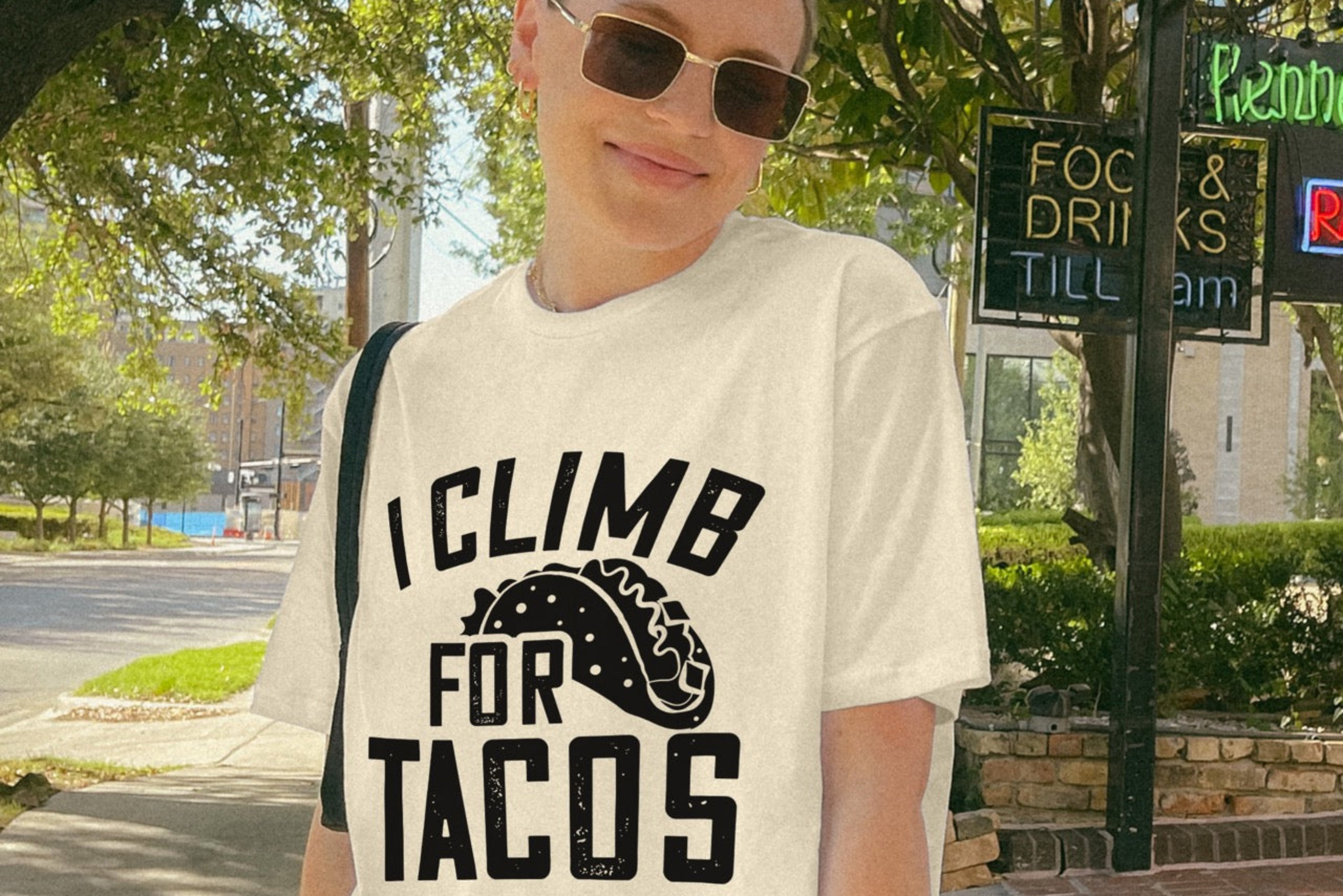 Woman wearing Natural (beige) l I climb for Tacos statement tee with bold distressed curved typography and detailed taco illustration for Mexican food-loving rock climbers and nature hikers. 