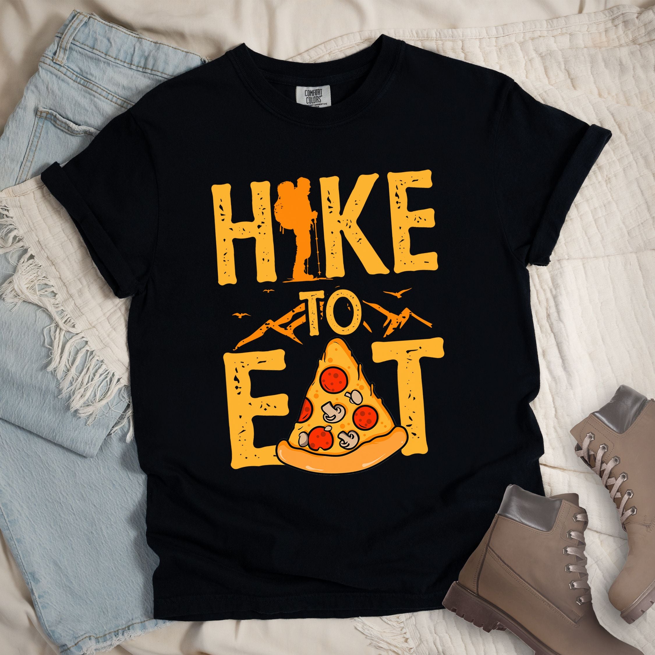 Black shirt with a Hiking design of a slice of pizza and shows 'Hike To Eat' phrase in bold text