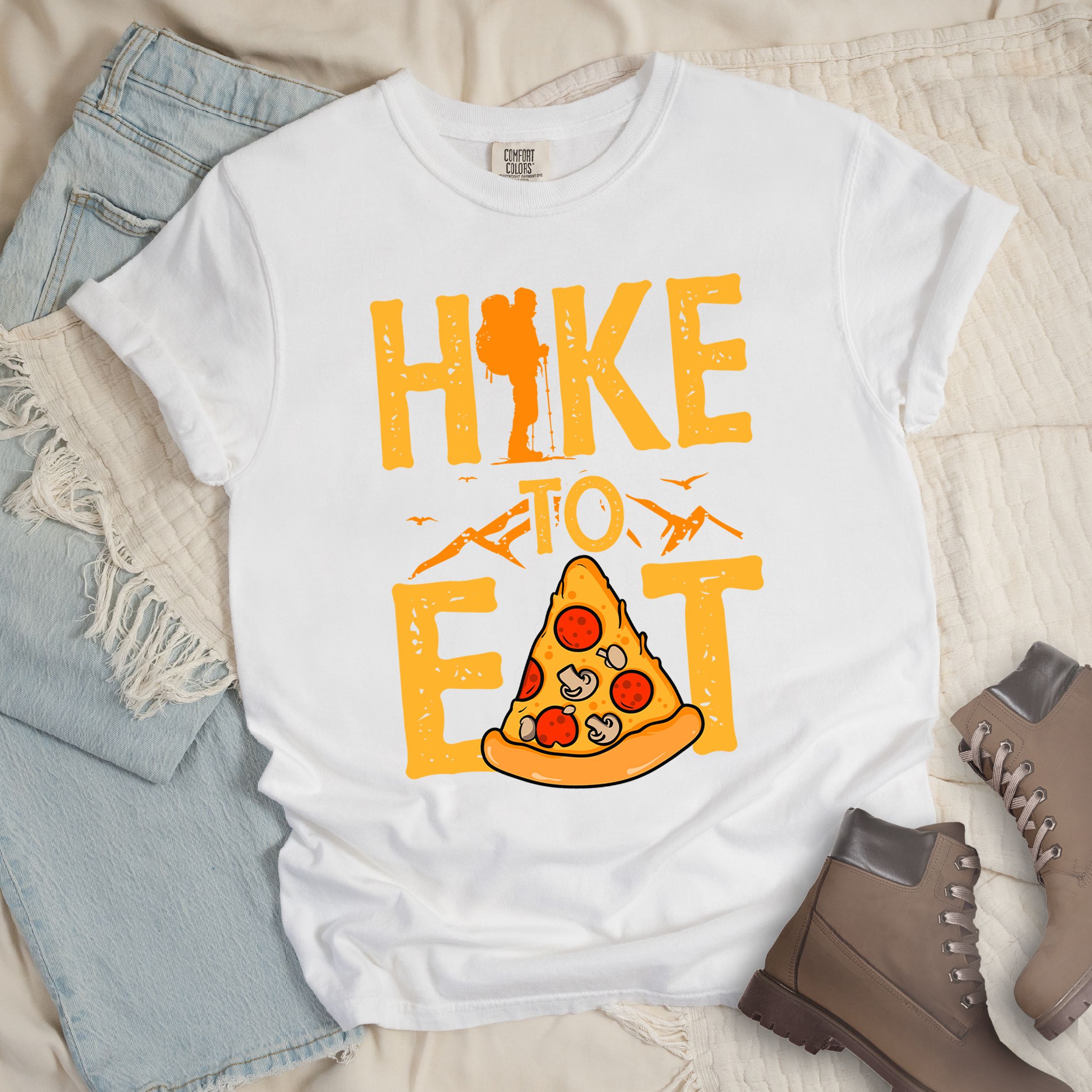 White shirt with a Hiking design of a slice of pizza and shows 'Hike To Eat' phrase in bold text