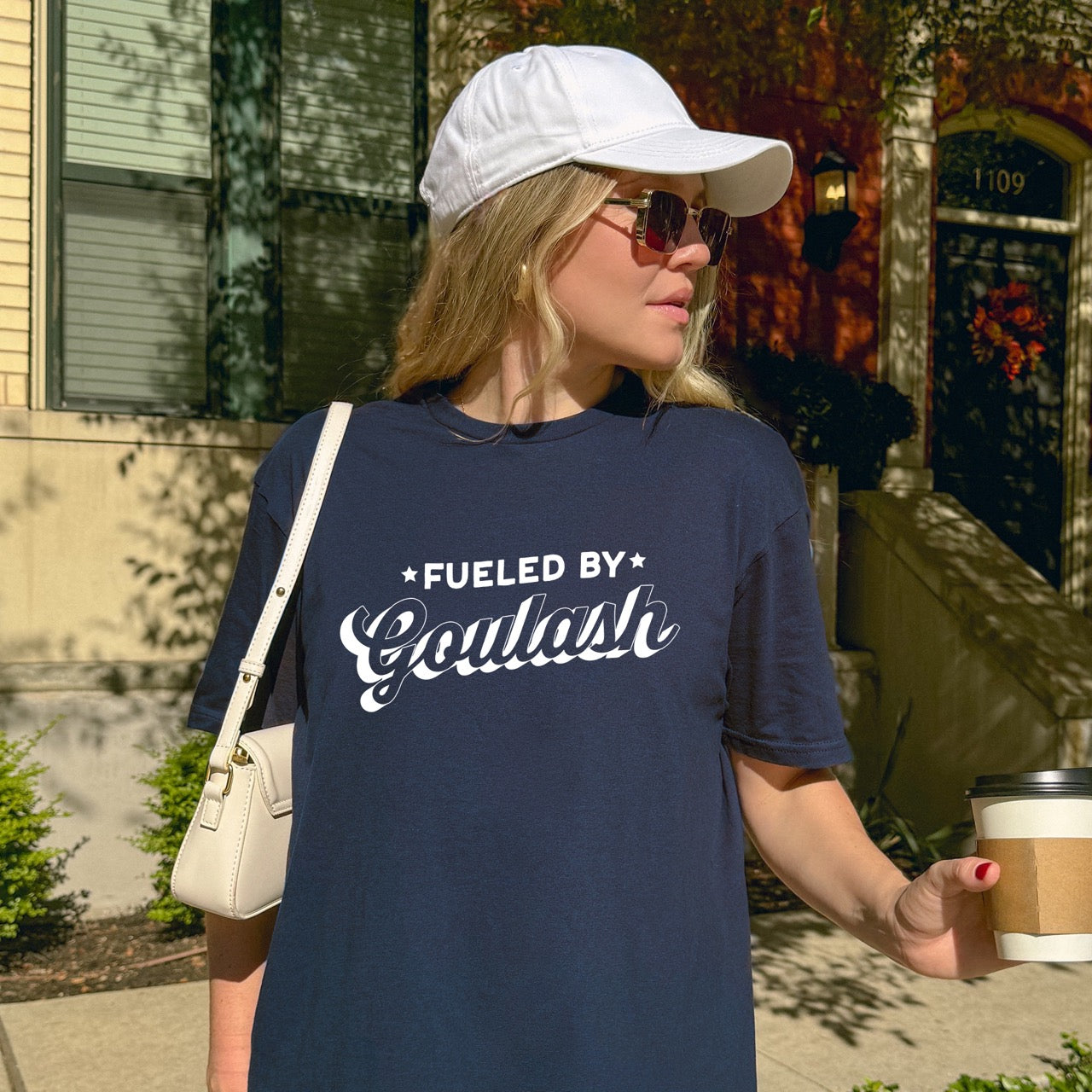  Woman wearing Navy Hungarian food lover  Fueled by Goulash statement shirt with bold distressed lettering and flowing script design featuring decorative stars for outdoor adventurers who love paprika-spiced comfort stew for hikers, climbers and foodies