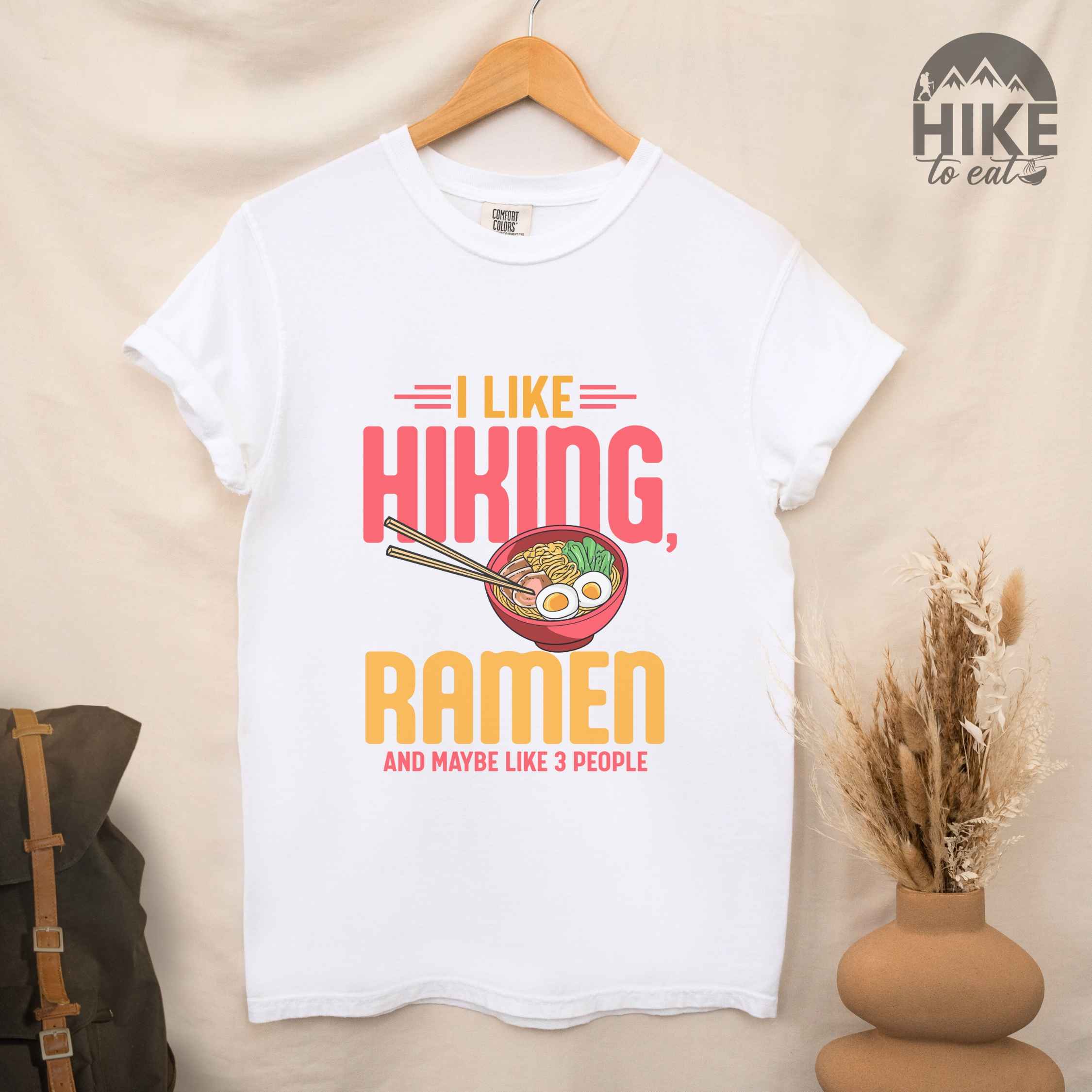 Hanging white "I like Hiking, Ramen and maybe like three people" colored vintage tee with bold typography, and illustrated bowl of ramen for foodies
