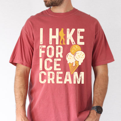 Crimson (Dark Pink) graphic t-shirt with 'I Hike for Ice Cream' text in cream lettering featuring orange hiker silhouette and vanilla and mango ice cream cone illustration with waffle cone.