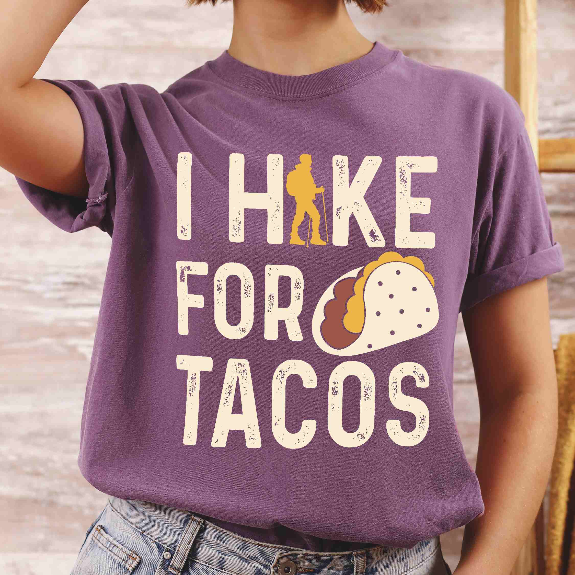 Woman wearing berry colored vintage tee with 'I Hike for Tacos' text in cream lettering, illustrated taco, and backpacker for taco lovers