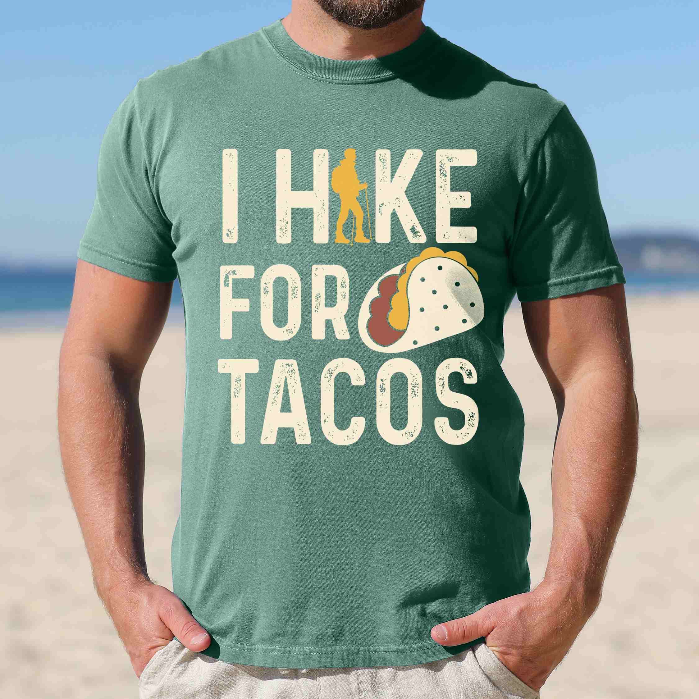 Man wearing light green colored vintage tee with 'I Hike for Tacos' text in cream lettering, illustrated taco, and backpacker for taco lovers