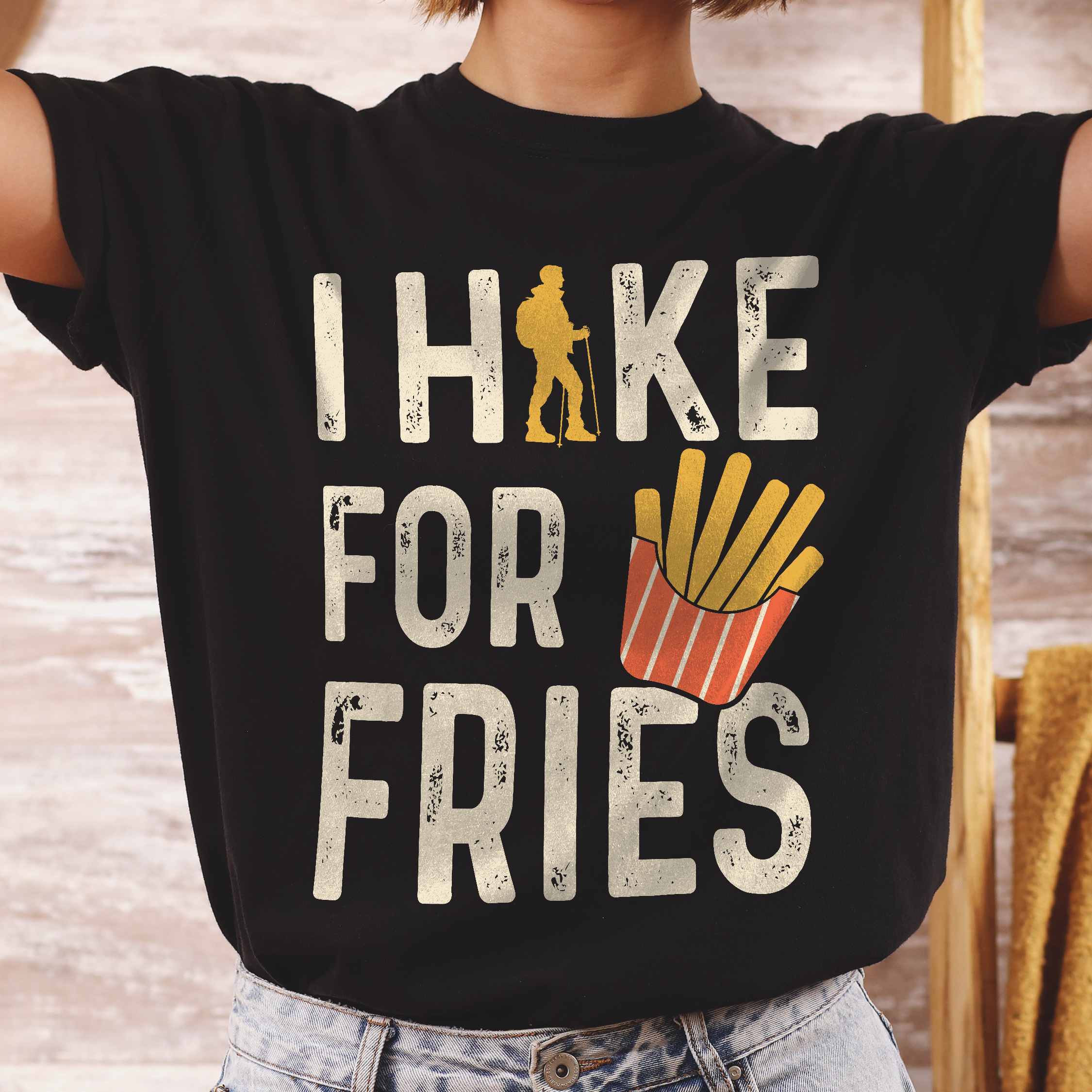 Woman wearing black 'I Hike for Tacos' text in cream lettering, illustrated french fries, and backpacker for french fries enthusiasts