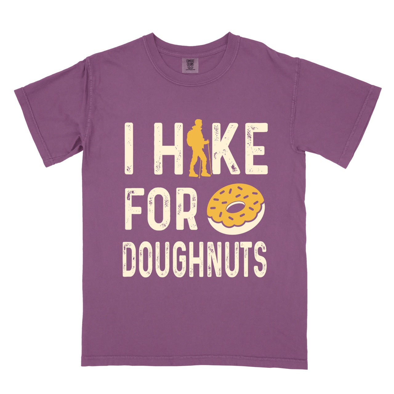 Berry (purple) Doughnut donut lover statement tee I Hike for Doughnuts with vintage distressed cream typography character silhouette with trekking pole and illustrated glazed doughnut with sprinkles on Comfort Colors shirt for sweet treat enthusiasts, hikers and foodies. 
