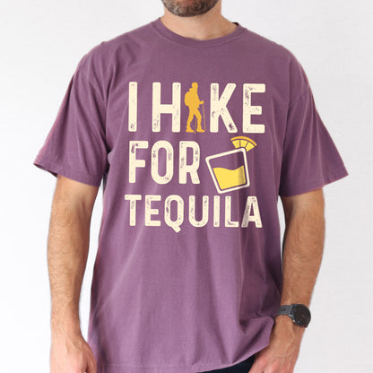 Berry (Dark Violet) graphic t-shirt with 'I Hike for Tequila' text in cream lettering featuring orange hiker silhouette and tequila shot glass illustration with lime garnish.