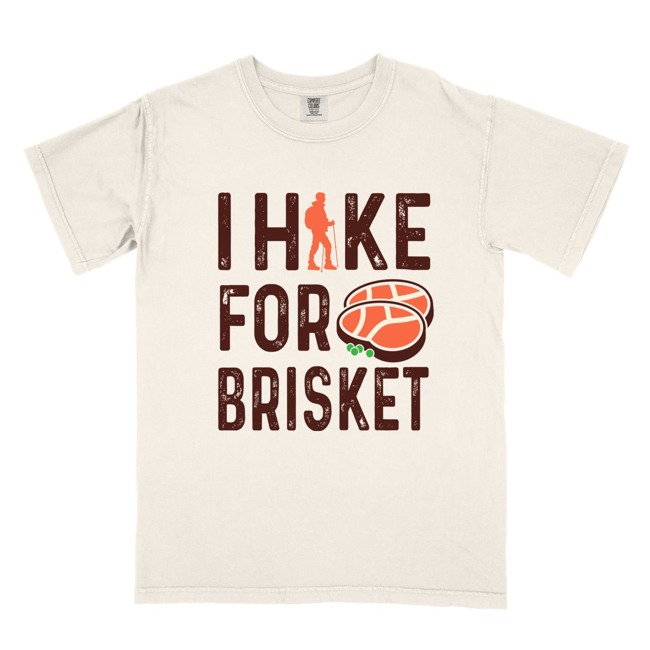  Ivory BBQ brisket lover statement tee I Hike for Brisket with distressed brown typography character silhouette with trekking pole and illustrated sliced smoked brisket with herb garnish on vintage Comfort Colors shirt for food motivated adventurers for hikers and foodies. 