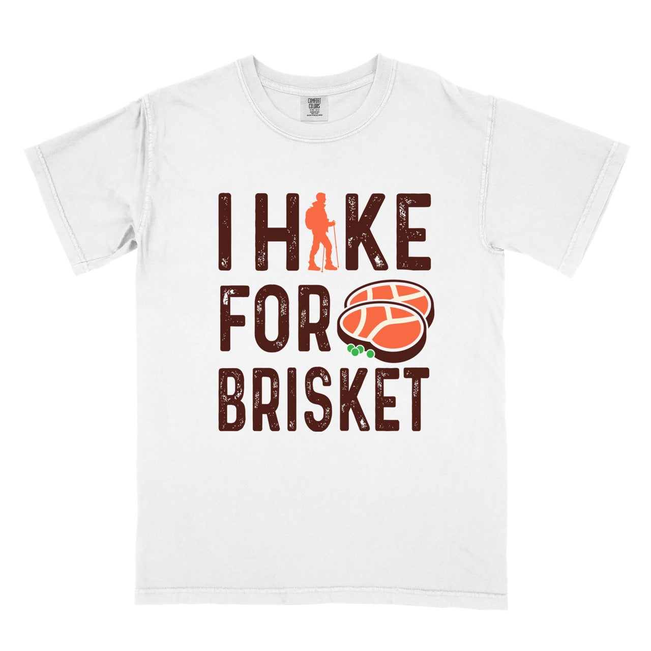 White BBQ brisket lover statement tee I Hike for Brisket with distressed brown typography character silhouette with trekking pole and illustrated sliced smoked brisket with herb garnish on vintage Comfort Colors shirt for food motivated adventurers for hikers and foodies. 