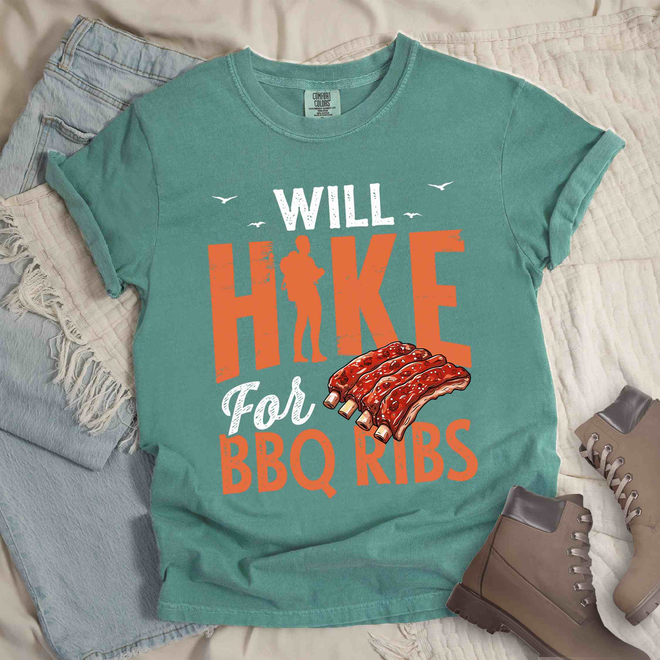Light green "Will Hike for BBQ Ribs" colored vintage tee with bold typography, birds, juicy grilled bbq ribs illustration, and backpacker for bbq enthusiasts