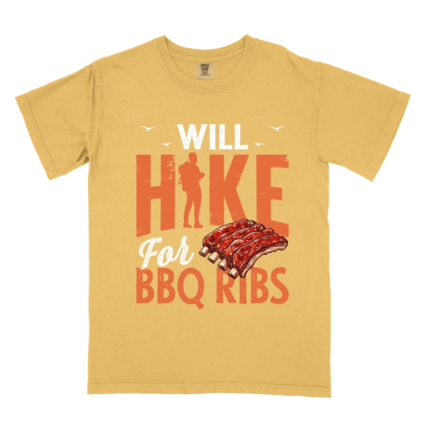 Mustard (Yellow) t-shirt with text "WILL HIKE For BBQ RIBS". "WILL" appears in white distressed letters at the top with small bird silhouettes. "HIKE" is in large orange distressed text with a hiker silhouette replacing the letter "I". "For" appears in white script, and "BBQ RIBS" in matching orange at the bottom. Between "For" and "BBQ RIBS" is an illustration of a rack of barbecue ribs with exposed bones.