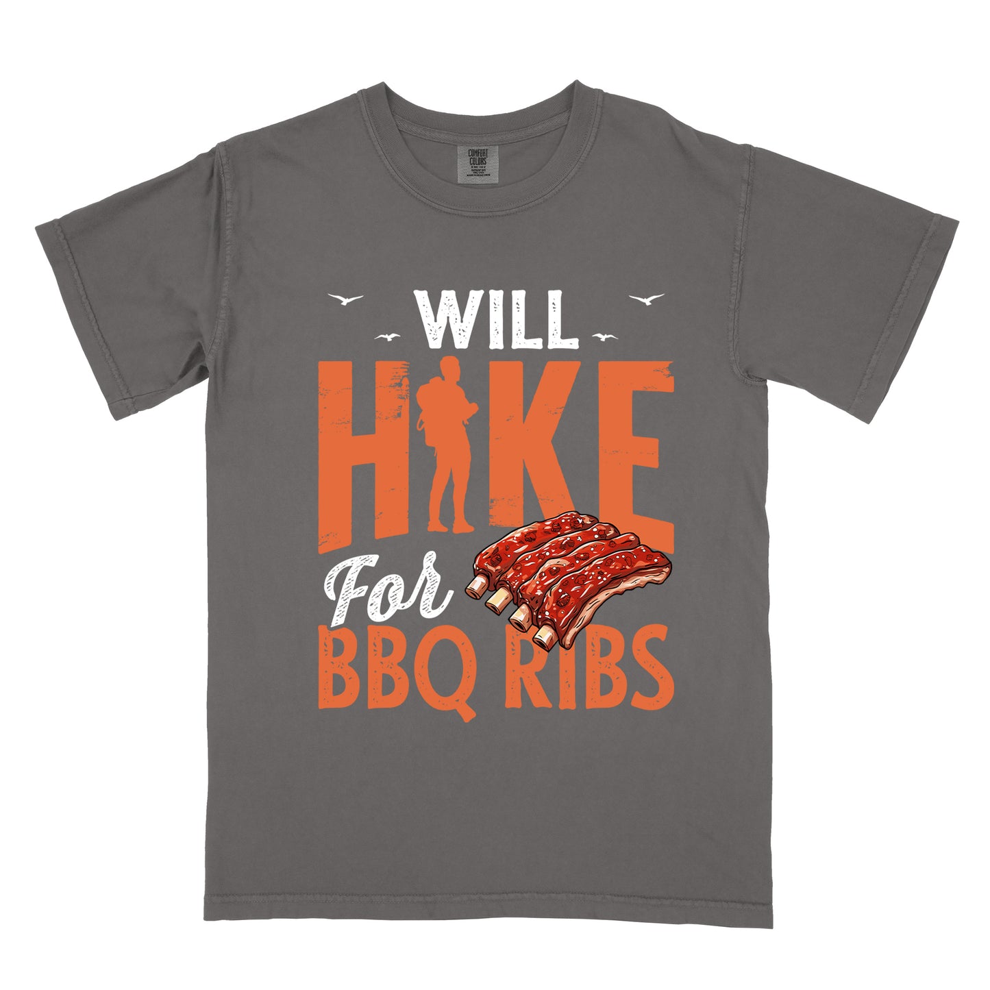 Pepper (Dark Gray) t-shirt with text "WILL HIKE For BBQ RIBS". "WILL" appears in white distressed letters at the top with small bird silhouettes. "HIKE" is in large orange distressed text with a hiker silhouette replacing the letter "I". "For" appears in white script, and "BBQ RIBS" in matching orange at the bottom. Between "For" and "BBQ RIBS" is an illustration of a rack of barbecue ribs with exposed bones.