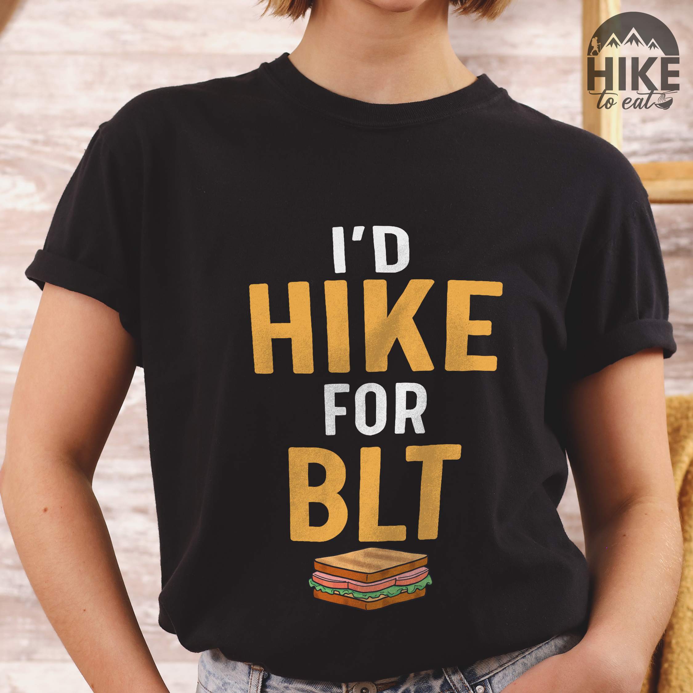 Woman wearing black "I'd Hike for BLT" colored vintage tee with bold typography, toasted BLT sandwich illustration, perfect for sandwich lovers