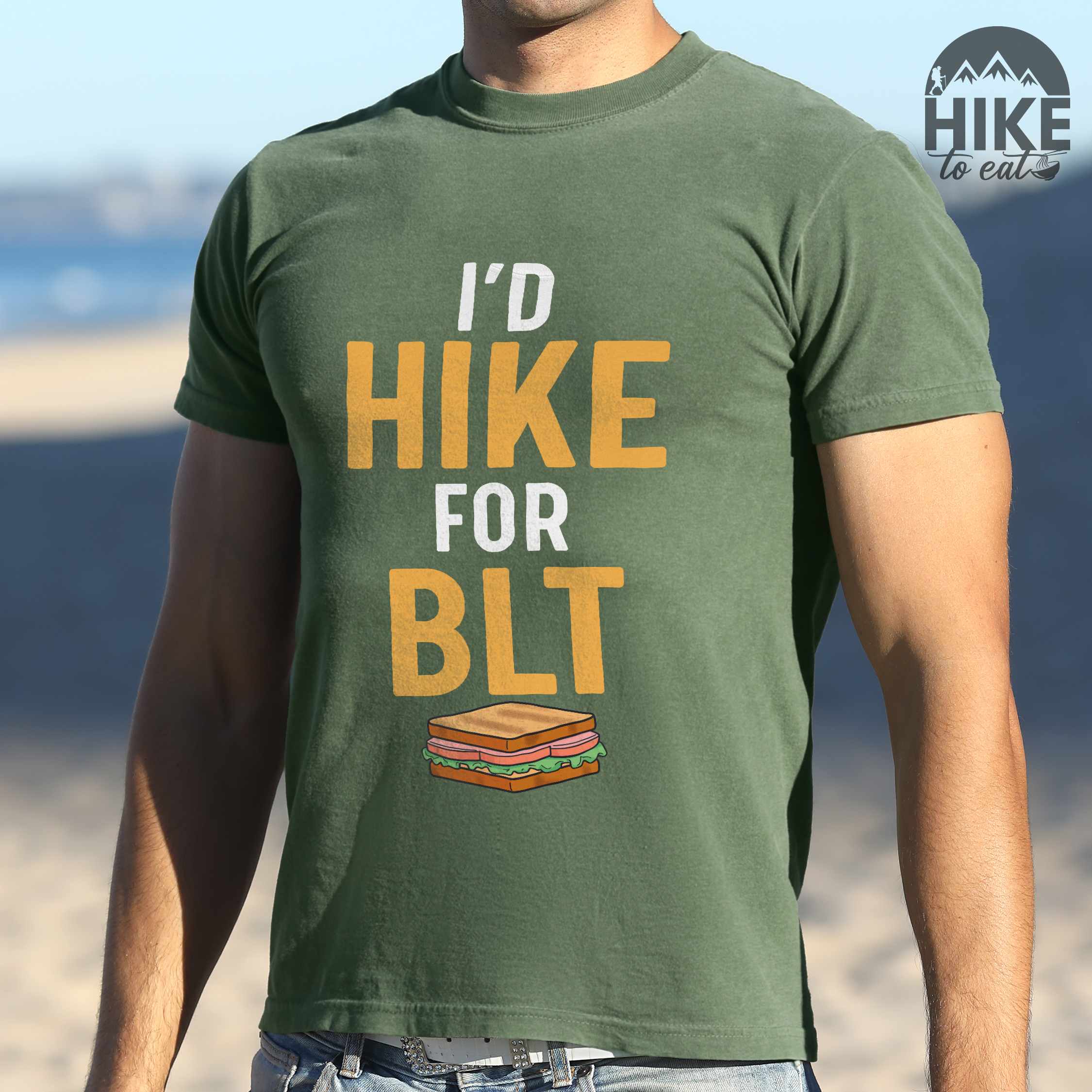 Man wearing moss "I'd Hike for BLT" colored vintage tee with bold typography, toasted BLT sandwich illustration, perfect for sandwich lovers