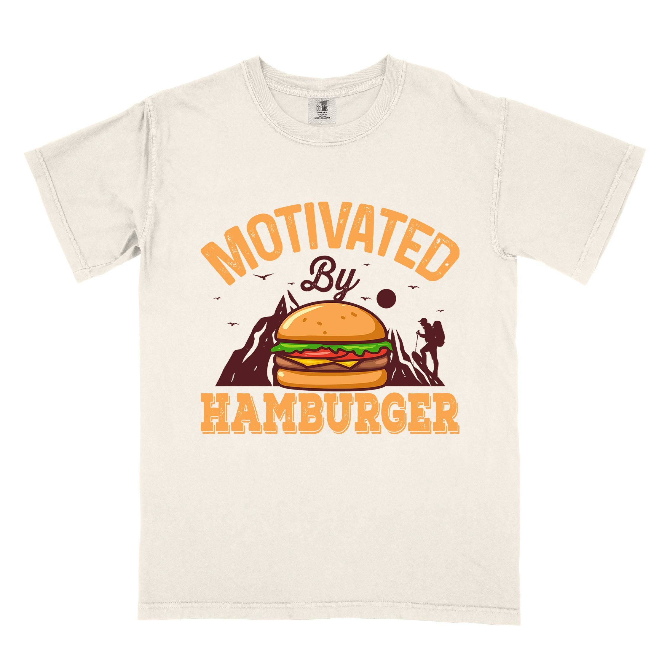 Ivory "Motivated by Hamburger" colored vintage tee with bold typography, birds, mountains, illustrated juicy hamburger, and backpacker for burger enthusiasts.