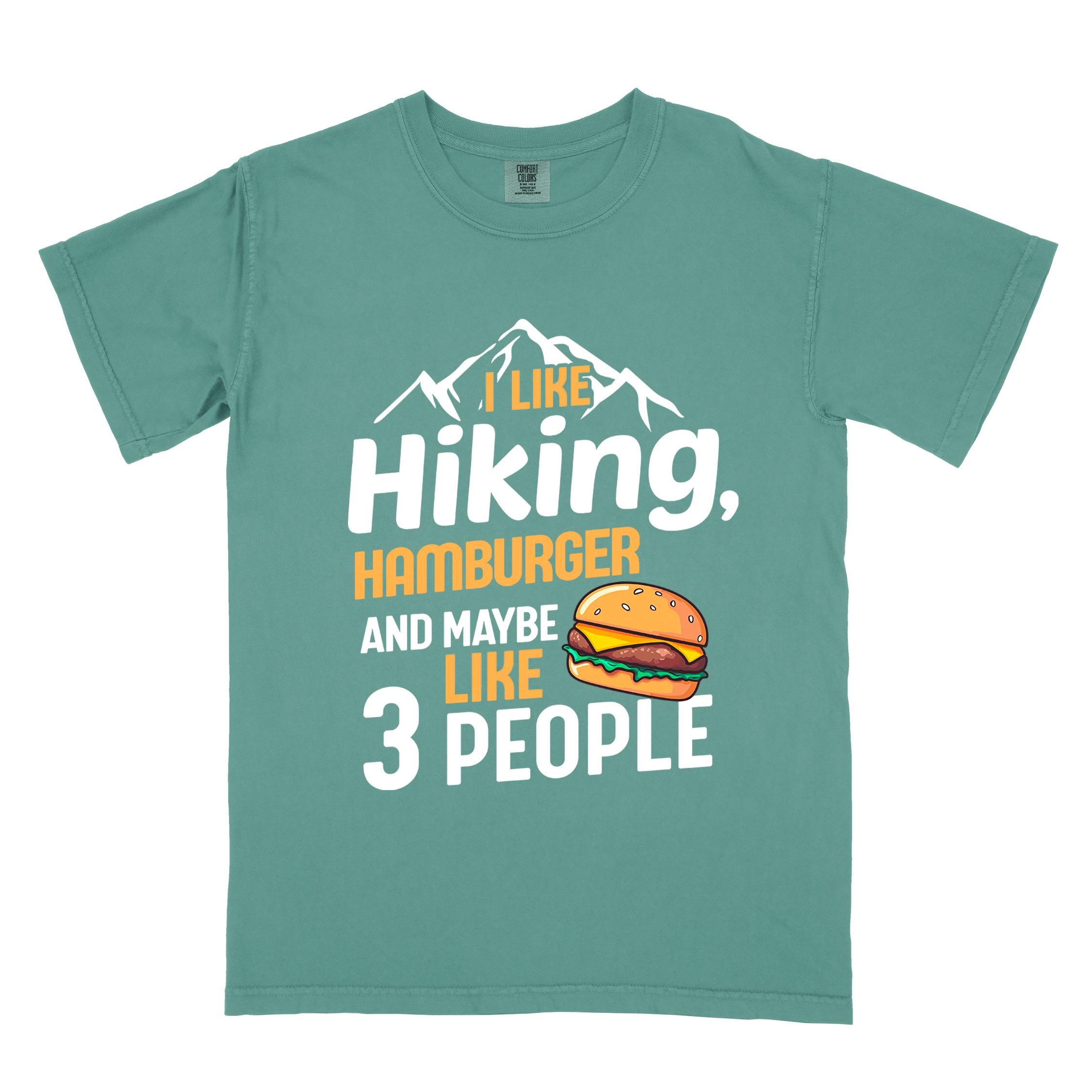 Light green "I like hiking, hamburger and maybe like three people" colored vintage tee with bold typography, birds, mountains, illustrated juicy hamburger, and backpacker for burger enthusiasts.