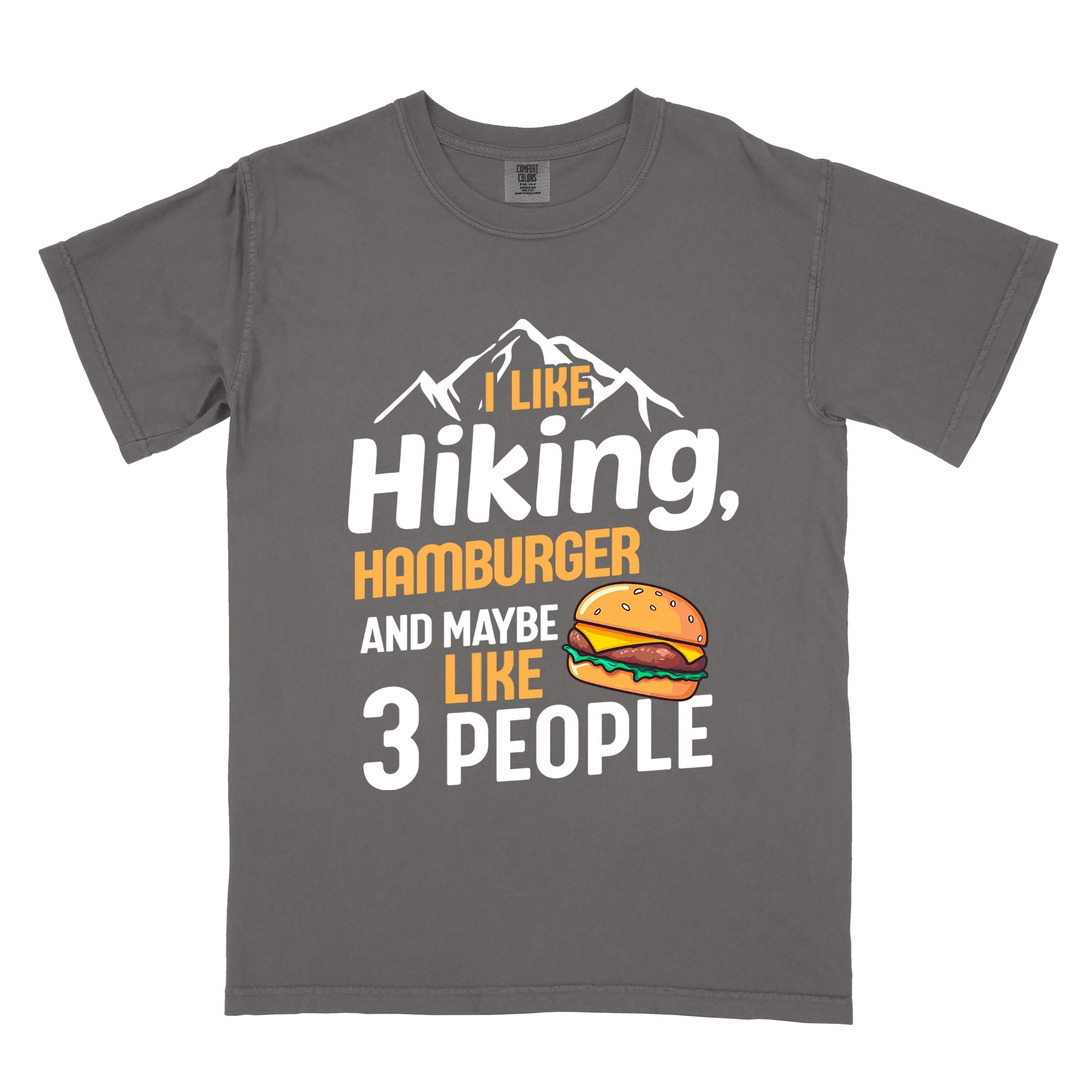 Pepper "I like hiking, hamburger and maybe like three people" colored vintage tee with bold typography, birds, mountains, illustrated juicy hamburger, and backpacker for burger enthusiasts.