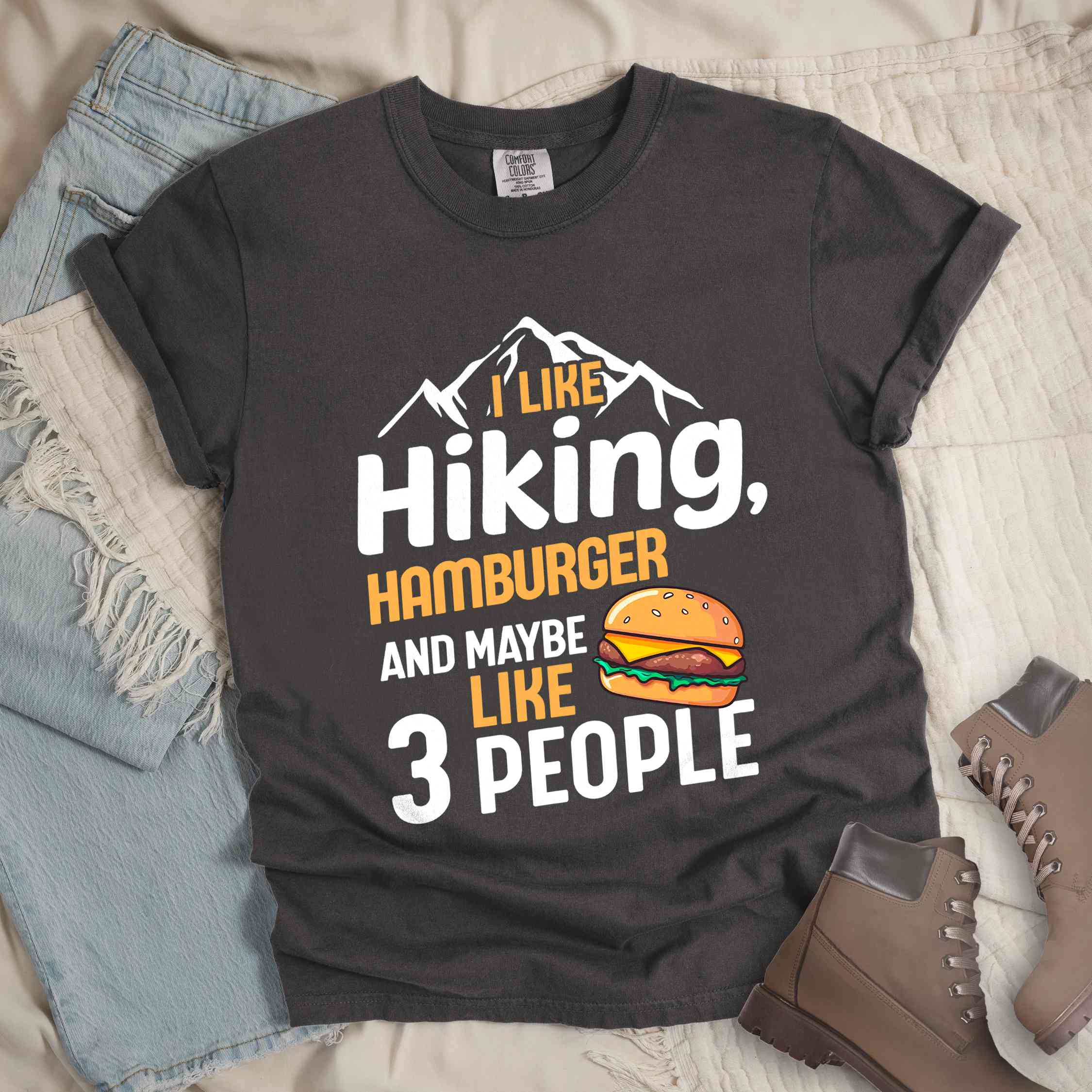 Pepper "I like hiking, hamburger and maybe like three people" colored vintage tee with bold typography, birds, mountains, illustrated juicy hamburger, and backpacker for burger enthusiasts.
