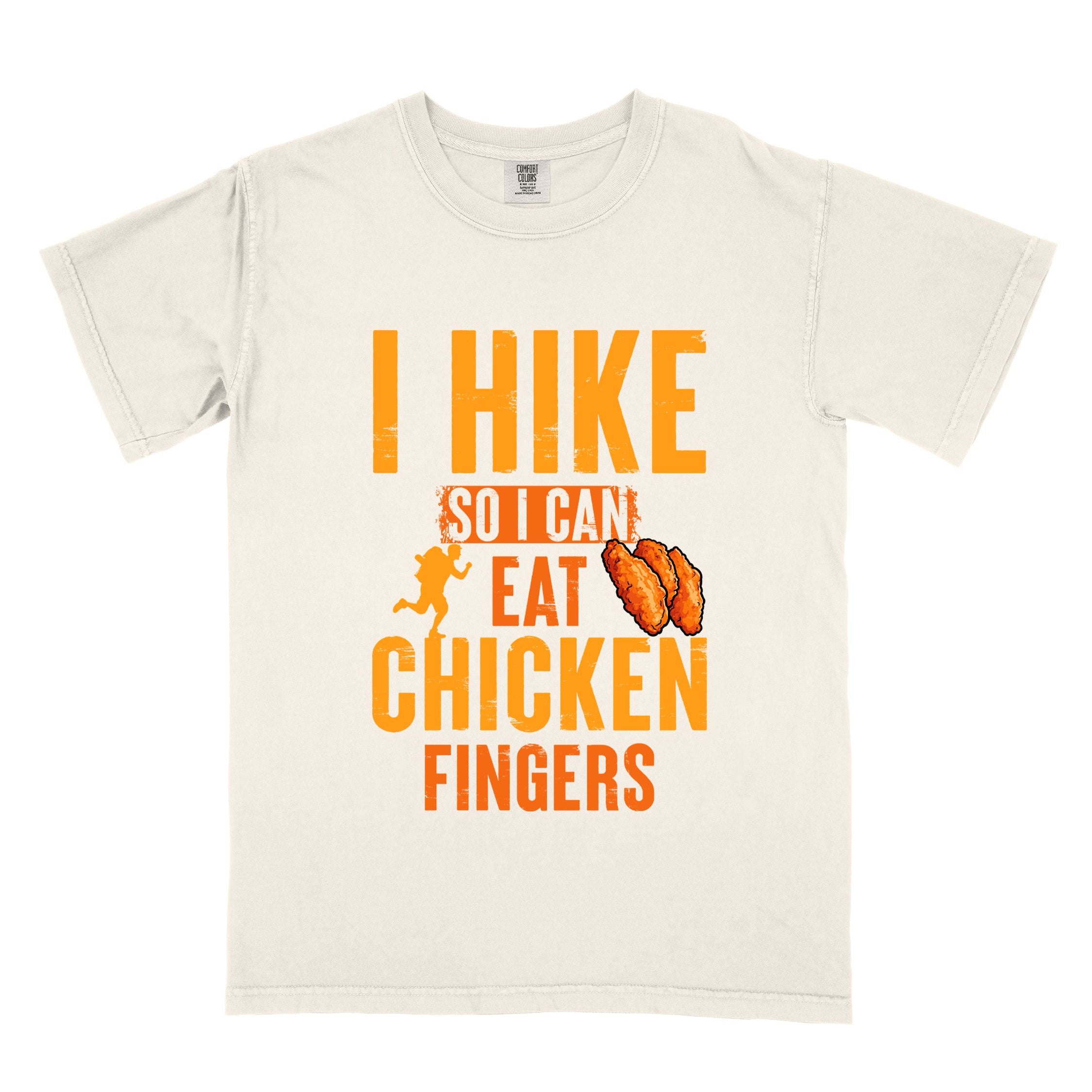Ivory "I Hike so I can eat Chicken Fingers" colored vintage tee with bold typography, illustrated crispy fried chicken fingers, perfect for comfort food lovers.