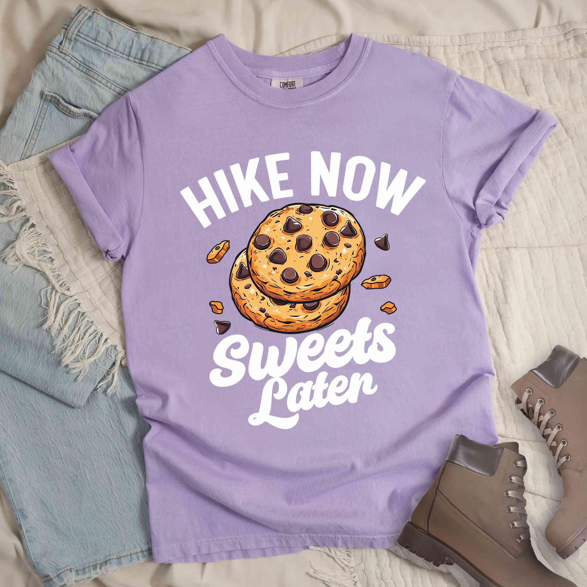 Orchid “Hike Now Sweets Later” colored vintage tee with bold and script typography, illustration of chocolate chip cookies with crumbs scattered around. Perfect for cookie lovers.