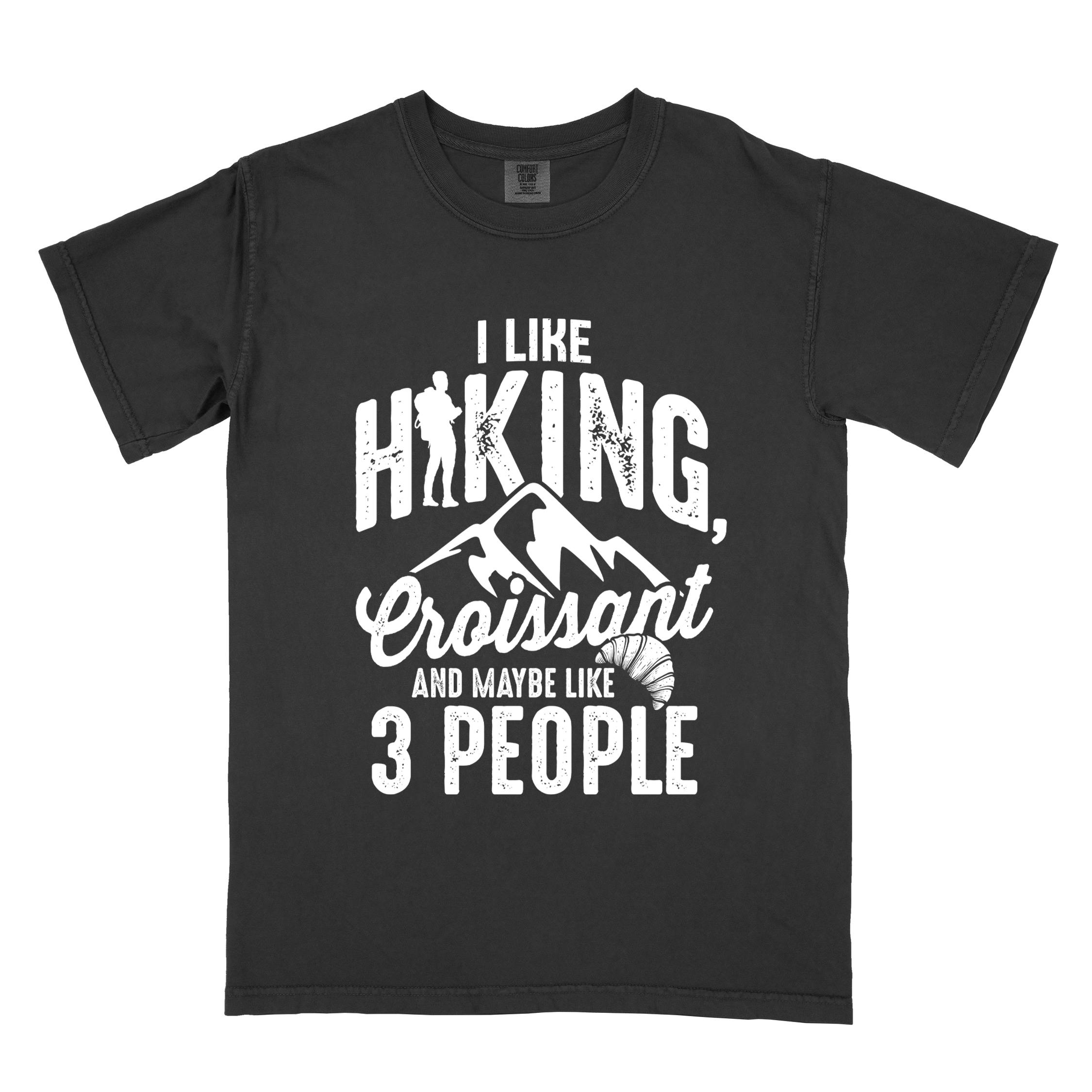 Black "I Like hiking, croissant and maybe like 3 people" colored vintage tee with bold typography, birds, mountains, illustrated croissant, and backpacker for pastry enthusiasts.
